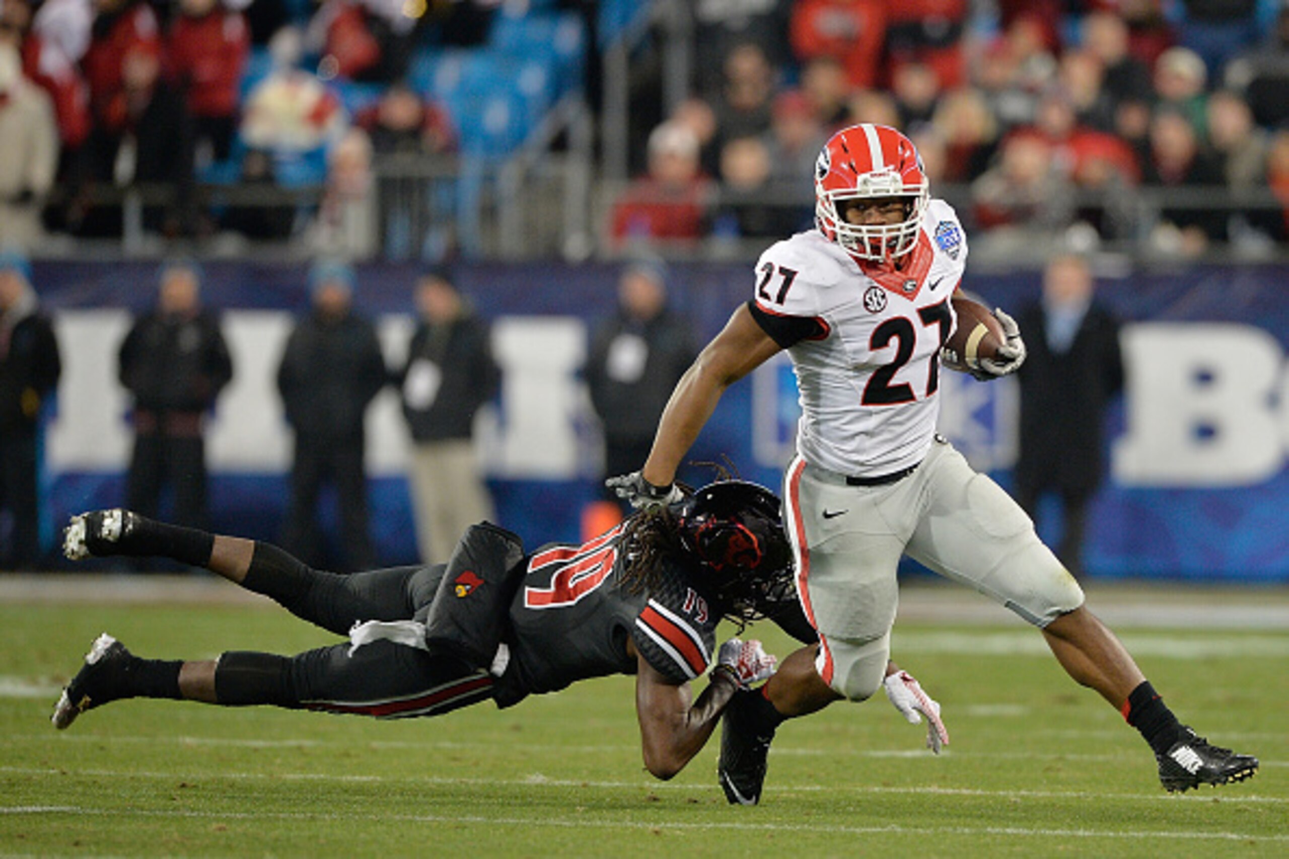 CHARLOTTE, NC - DECEMBER 30:  Nick Chubb #27 of the Georgia Bulldogs breaks away from Terell Floyd #19 of the Louisville Cardinals during the Belk Bowl at Bank of America Stadium on December 30, 2014 in Charlotte, North Carolina.  (Photo by Grant Halverso