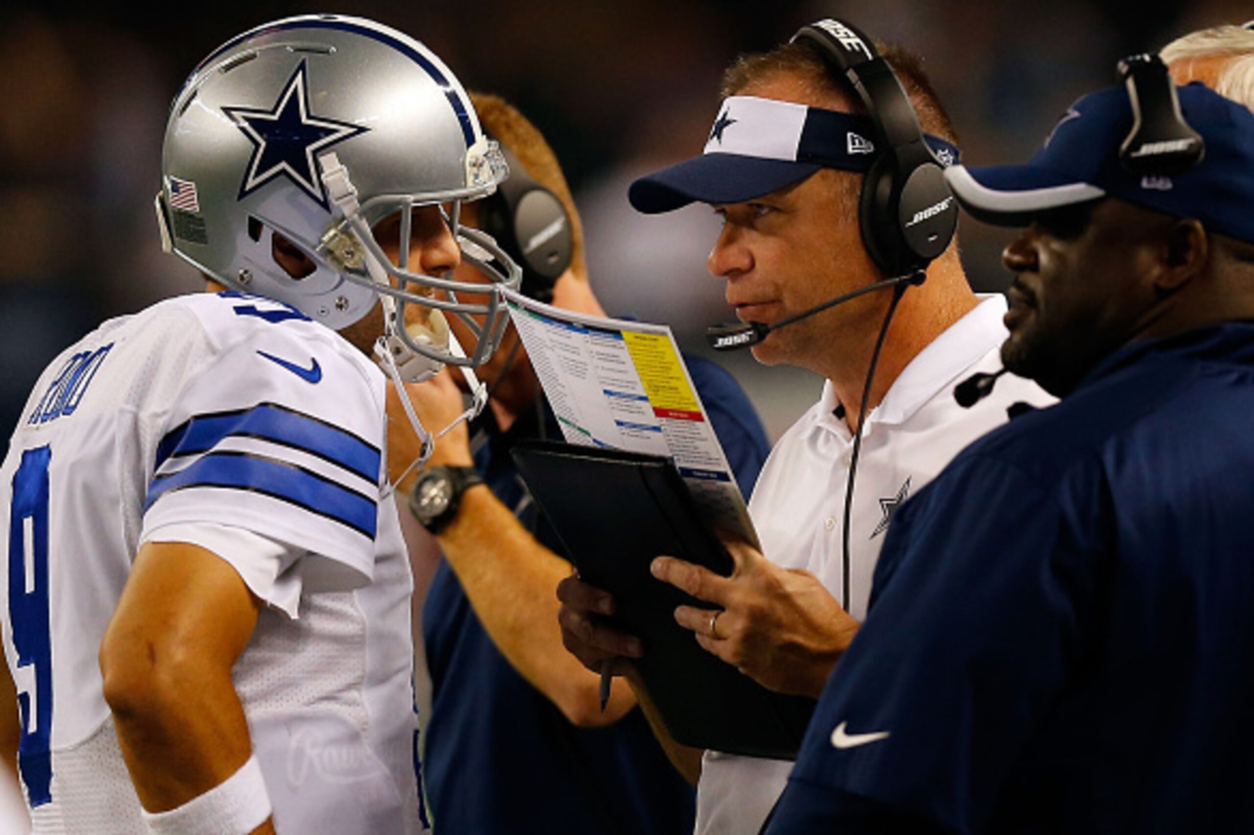 ARLINGTON, TX - OCTOBER 27:  Tony Romo #9 of the Dallas Cowboys talks with assistant coach Scott Linehan  during the second half against the Washington Redskins at AT&T Stadium on October 27, 2014 in Arlington, Texas.  (Photo by Tom Pennington/Getty Image