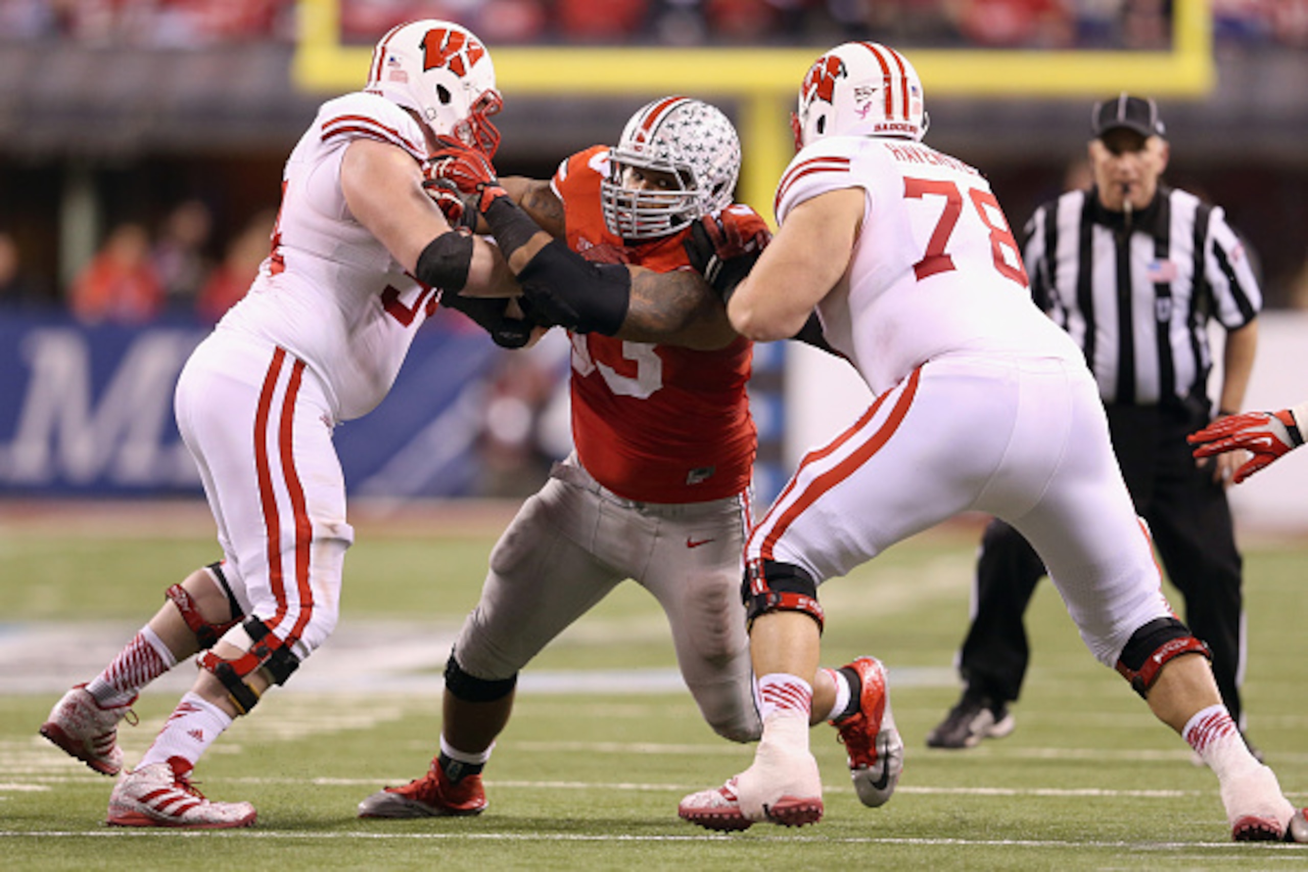 INDIANAPOLIS, IN - DECEMBER 06: Defensive lineman Michael Bennett plays while wearing #53 to honor late teammate Kosta Karageorge of the Ohio State Buckeyes during the Big Ten Championship against the Wisconsin Badgers at Lucas Oil Stadium on December 6, INDIANAPOLIS, IN - DECEMBER 06: Defensive lineman Michael Bennett plays while wearing #53 to honor late teammate Kosta Karageorge of the Ohio State Buckeyes during the Big Ten Championship against the Wisconsin Badgers at Lucas Oil Stadium on December 6,