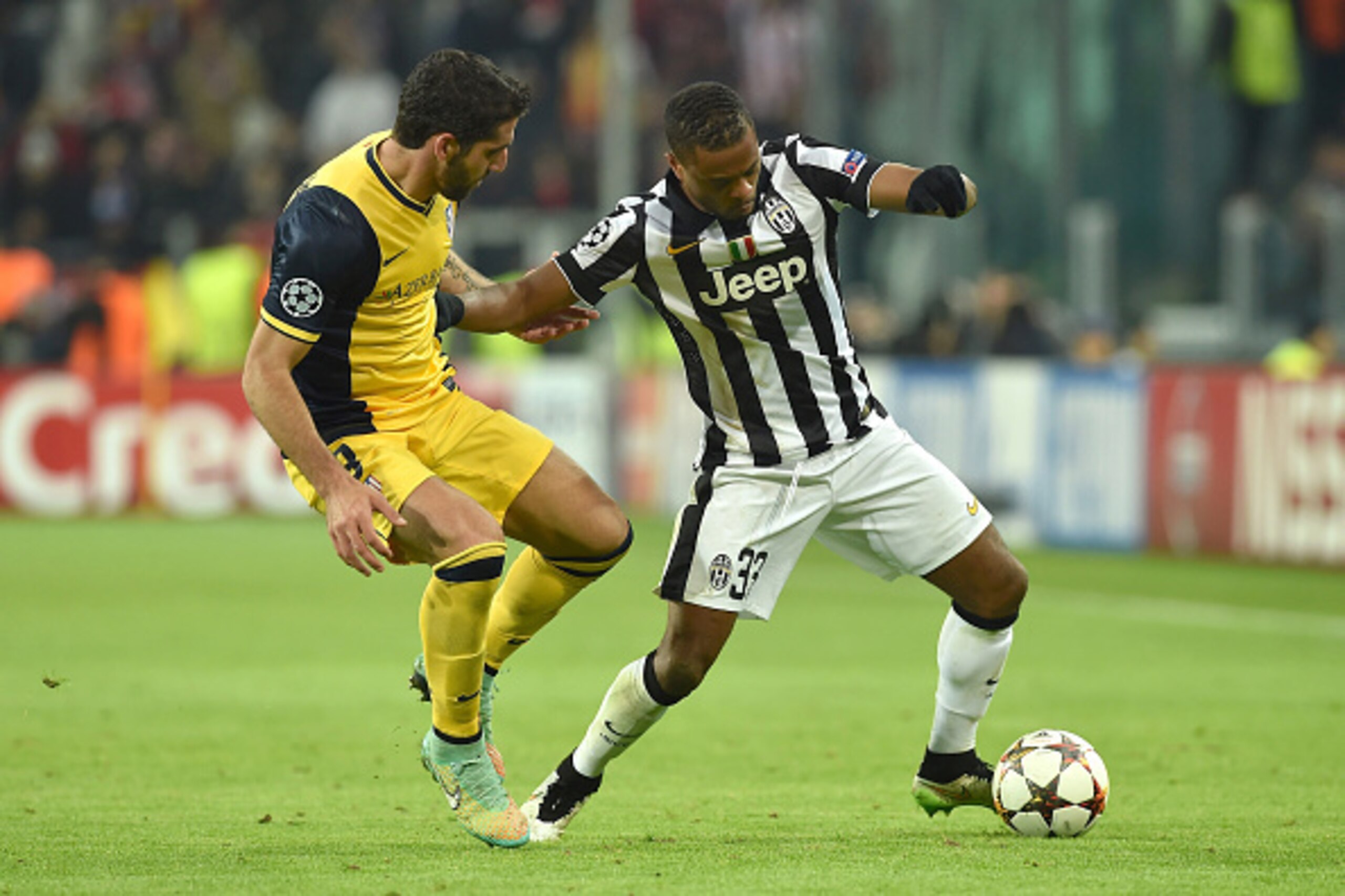 TURIN, ITALY - DECEMBER 09:  Patrice Evra (R) of Juventus is challenged by Raul Garcia of Club Atletico de Madrid during the UEFA Champions League group A match between Juventus and Club Atletico de Madrid at Juventus Arena on December 9, 2014 in Turin, I