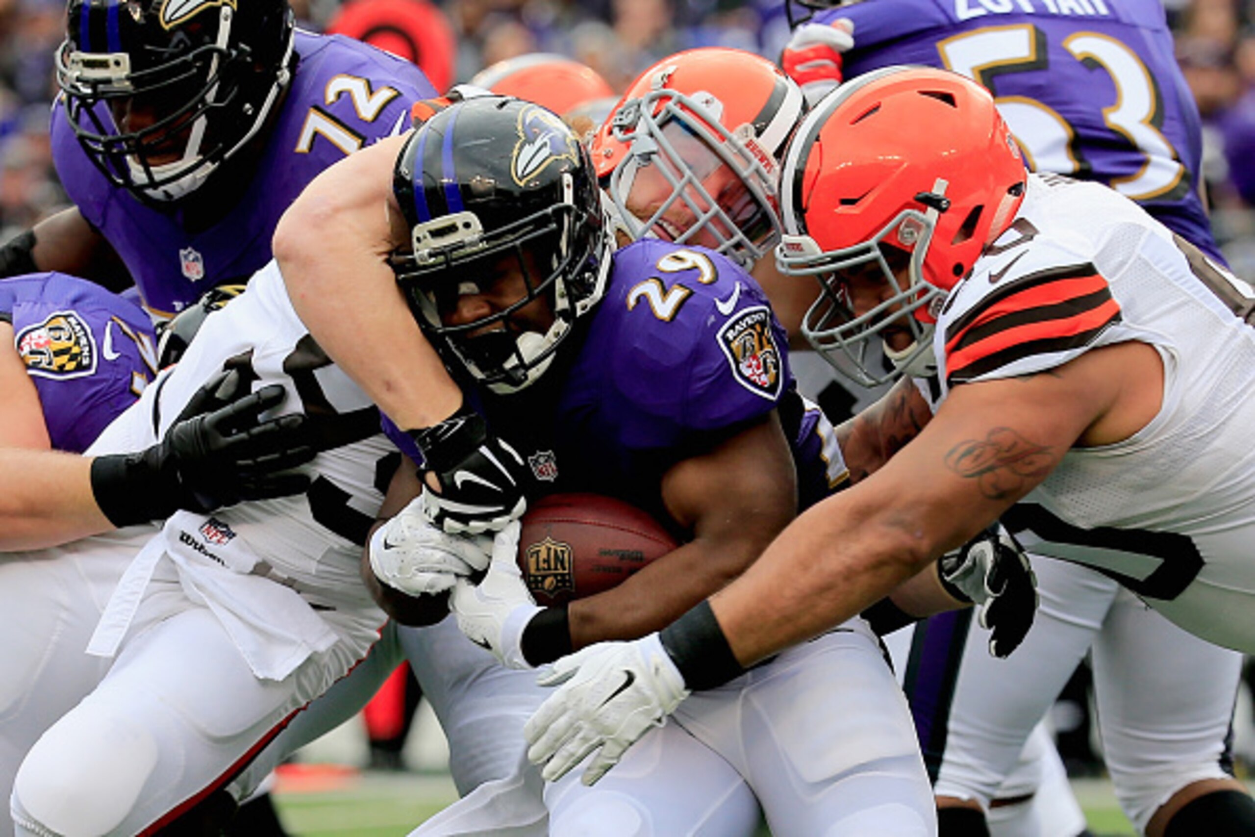 BALTIMORE, MD - DECEMBER 28: Running back Justin Forsett #29 of the Baltimore Ravens is tackled by outside linebacker Paul Kruger #99 and defensive end Billy Winn #90 of the Cleveland Browns in the first quarter of a game at M&T Bank Stadium on December 2