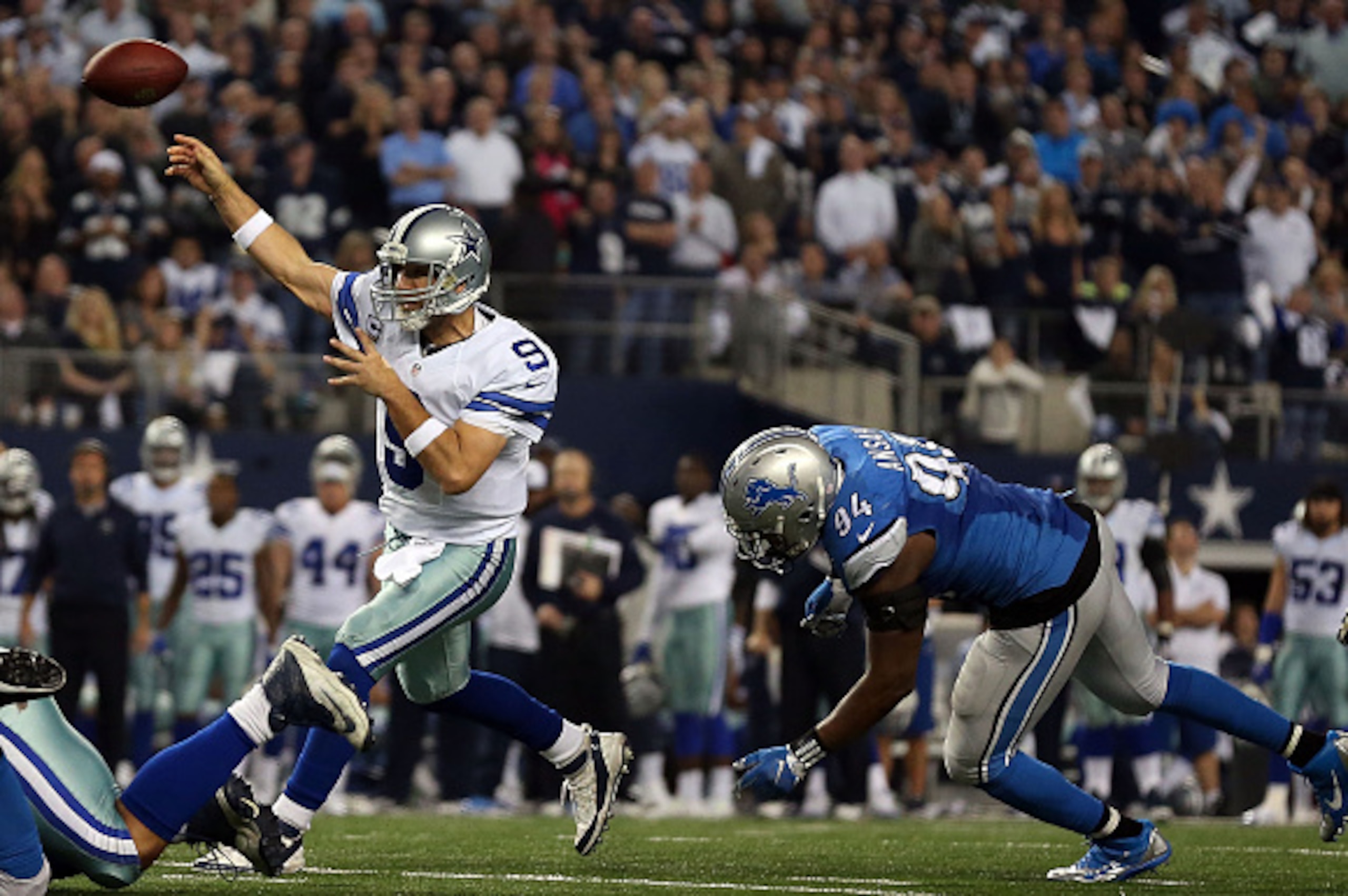 ARLINGTON, TX - JANUARY 04:  Tony Romo #9 of the Dallas Cowboys throws a touchdown pass to Terrance Williams #83 of the Dallas Cowboys as Ezekiel Ansah #94 of the Detroit Lions rushes during the second half of their NFC Wild Card Playoff game at AT&T Stad