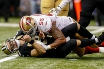 Nov 9, 2014; New Orleans, LA, USA; New Orleans Saints quarterback Drew Brees (9) is tackled by San Francisco 49ers outside linebacker Ahmad Brooks (55) during the fourth quarter at Mercedes-Benz Superdome. The 49ers won 27-24 in overtime.  Mandatory Credi