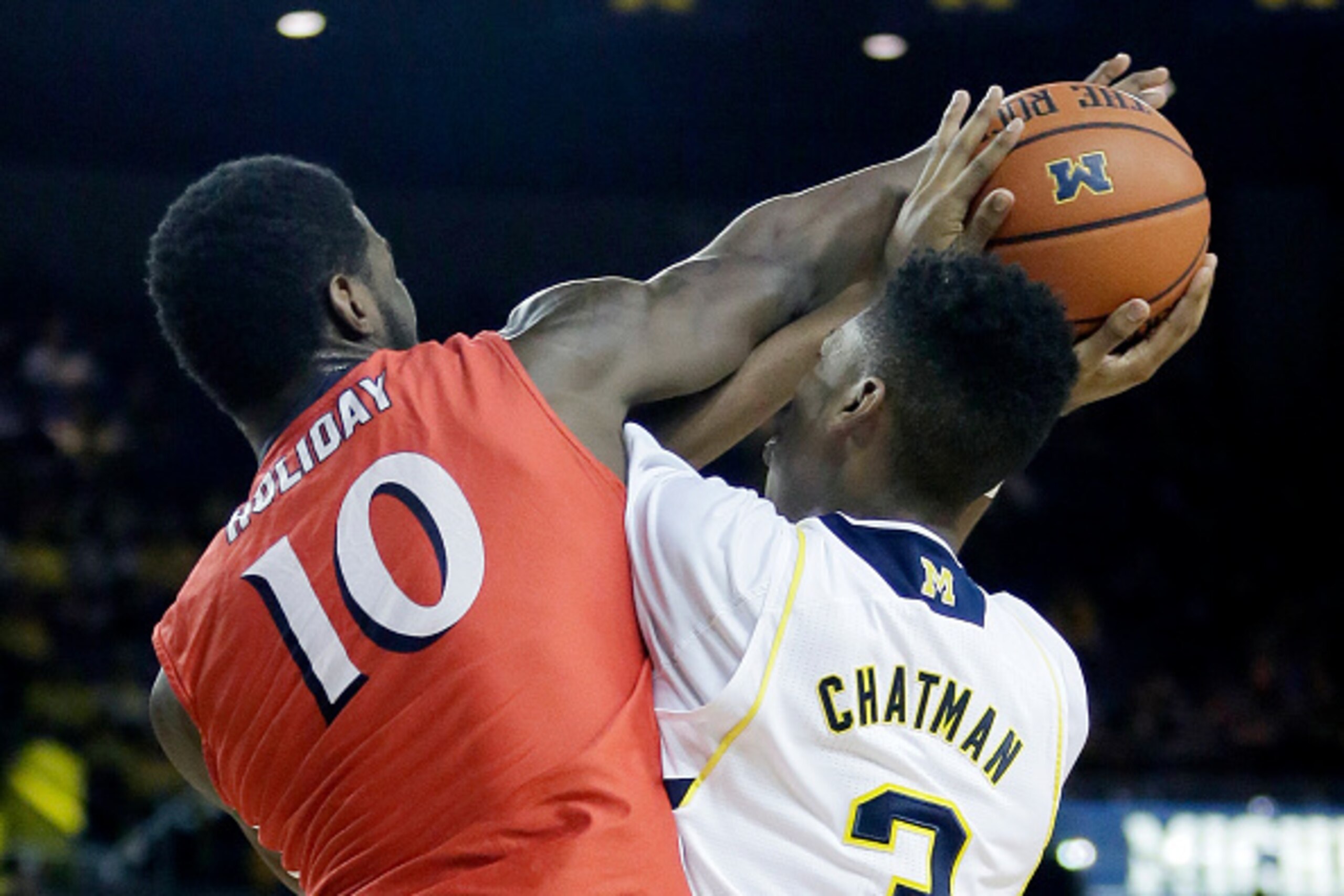 ANN ARBOR, MI - DECEMBER 6:  Daquan Holiday #10 of the New Jersey Institute of Technology Highlanders fouls Kameron Chatman #3 of the Michigan Wolverines while trying to block a shot during the first half at Crisler Arena on December 6, 2014 in Ann Arbor,