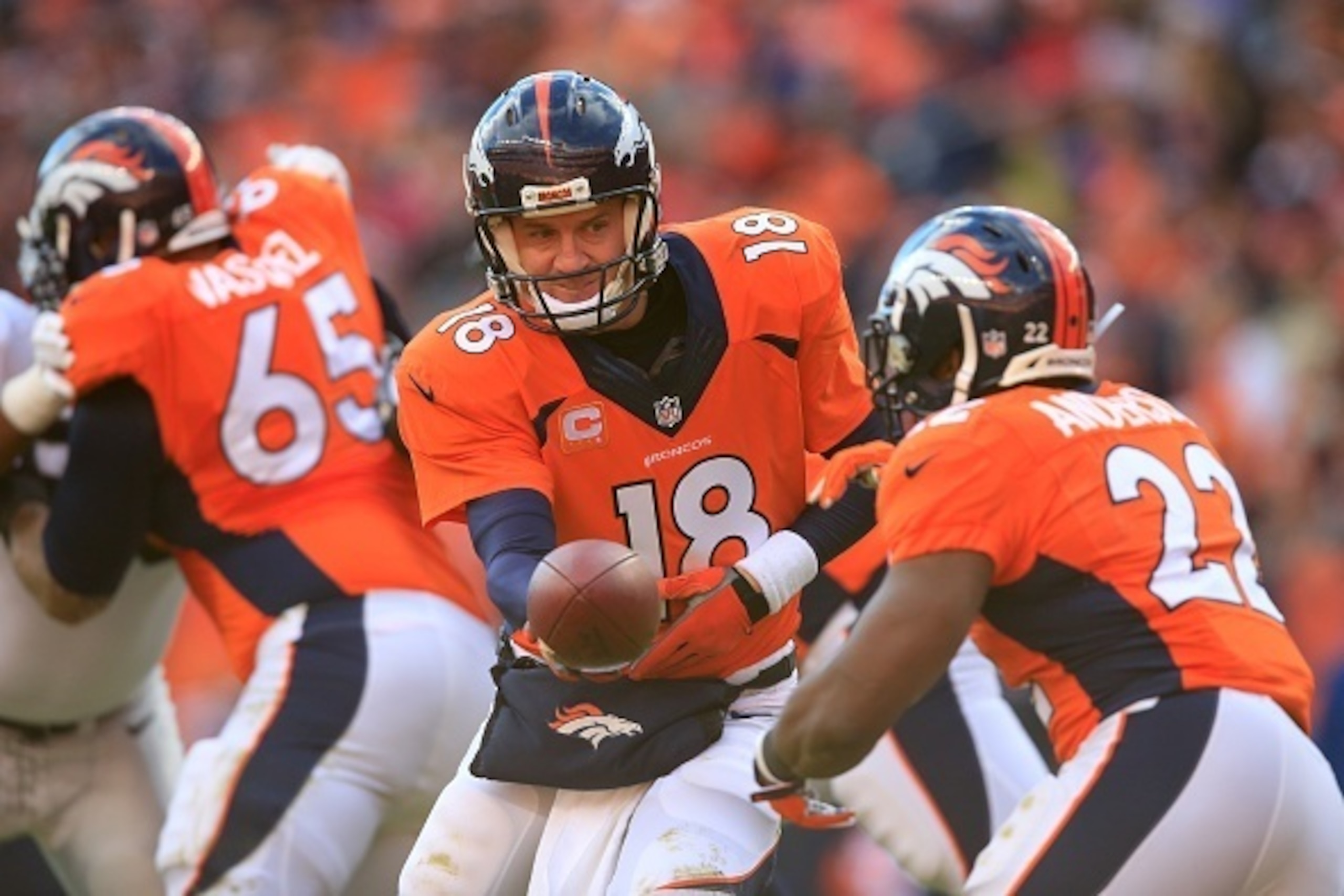 DENVER, CO - DECEMBER 28:  Quarterback Peyton Manning #18 of the Denver Broncos hands off to running back C.J. Anderson #22 against the Oakland Raiders during a game at Sports Authority Field at Mile High on December 28, 2014 in Denver, Colorado.  (Photo 