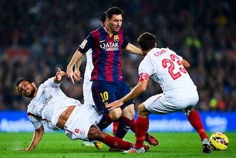 BARCELONA, SPAIN - NOVEMBER 22:  Lionel Messi of FC Barcelona duels for the ball with Daniel Filipe Martins Carrico (L) and Jorge Andujar Moreno 'Coke' of Sevilla FC of Sevilla FCat Camp Nou on November 22, 2014 in Barcelona, Spain.  (Photo by David Ramos