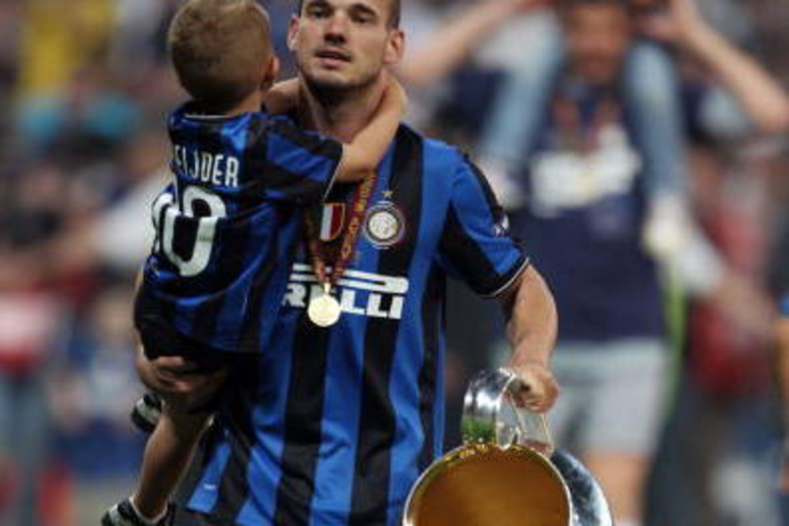 MADRID, SPAIN - MAY 22: Wesley Sneijder of Inter Milan and his son celebrate with the UEFA Champions League trophy at the end of the UEFA Champions League Final match between FC Bayern Muenchen and Inter Milan at the Estadio Santiago Bernabeu on May 22, 2