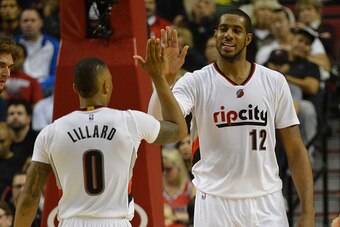 PORTLAND, OR - NOVEMBER 04: Damian Lillard #0 of the Portland Trail Blazers celebrates a basket by LaMarcus Aldridge #12 of the Portland Trail Blazers during the fourth quarter of the game against the Cleveland Cavaliers at Moda Center on November 4, 2014