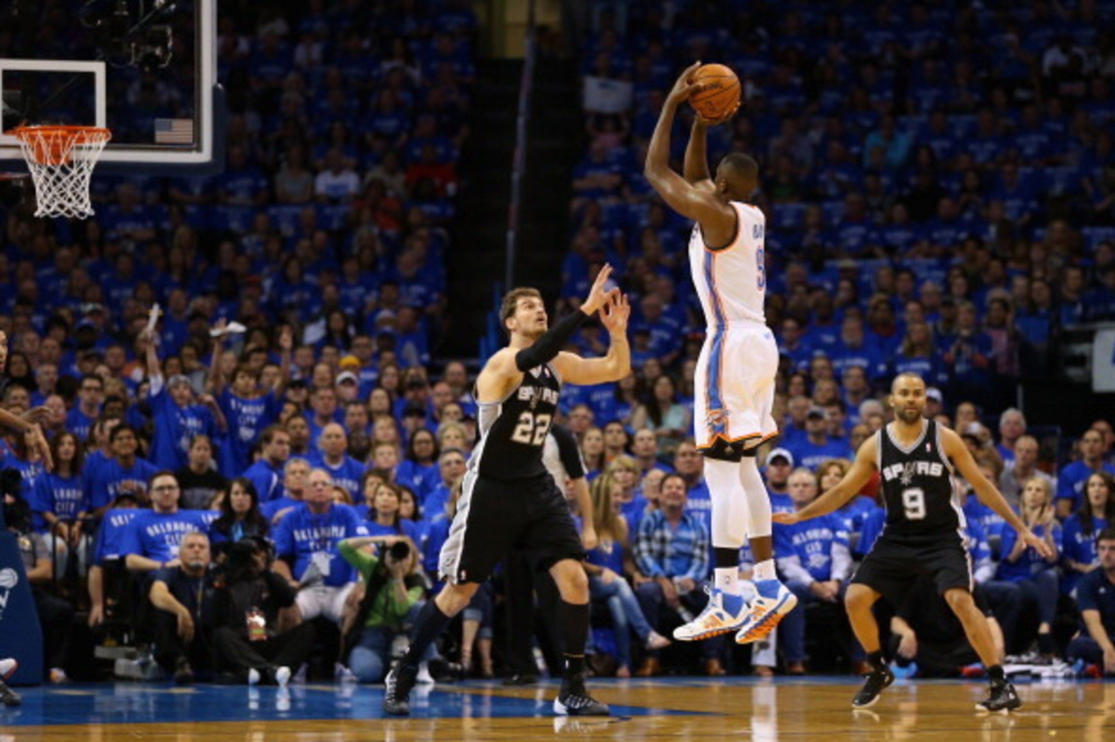 OKLAHOMA CITY, OK - MAY 25: Serge Ibaka #9 of the Oklahoma City Thunder shoots against Tiago Splitter #22 of the San Antonio Spurs during Game Three of the Western Conference Finals of the 2014 NBA Playoffs at Chesapeake Energy Arena on May 25, 2014 in Ok