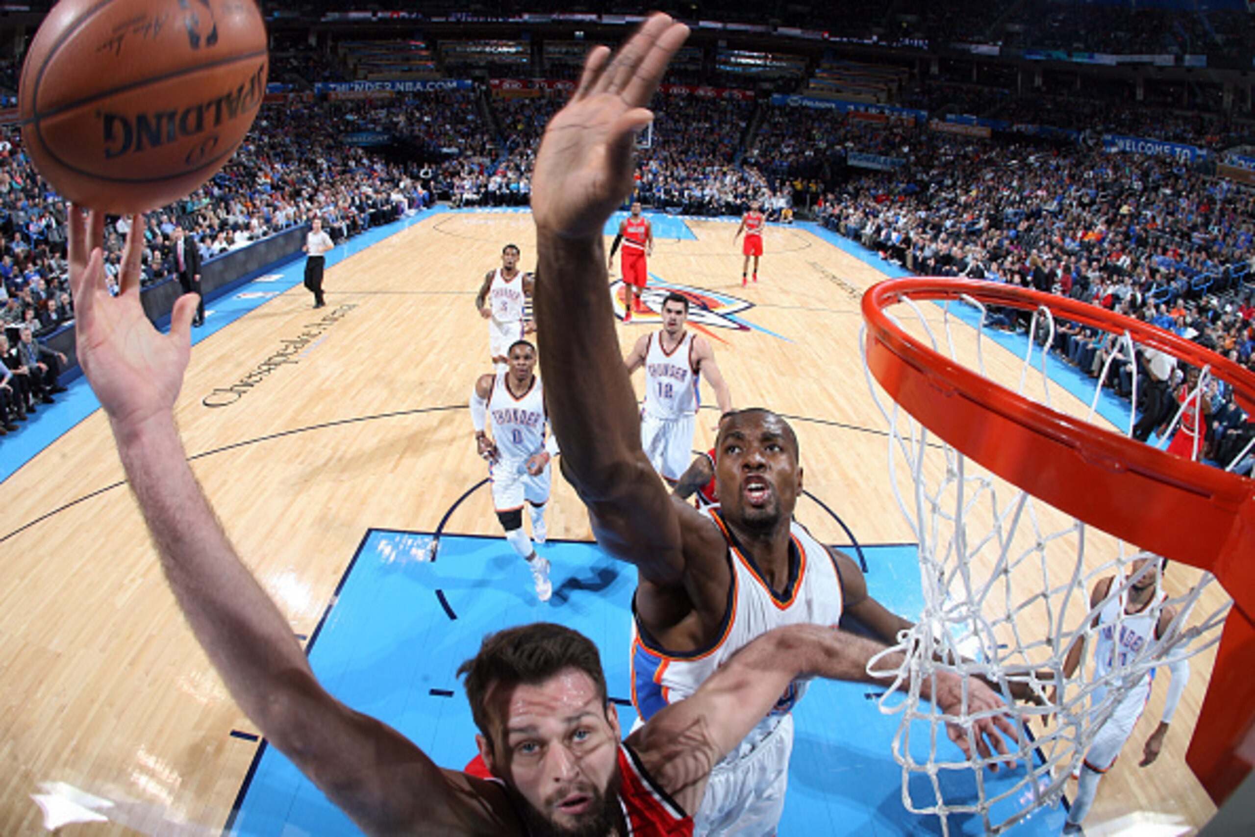 OKLAHOMA CITY, OK- DECEMBER 23: Joel Freeland #19 of the Portland Trail Blazers shoots against Serge Ibaka #9 of the Oklahoma City Thunder on December 23, 2014 at Chesapeake Energy Arena in Oklahoma City, OK. NOTE TO USER: User expressly acknowledges and 