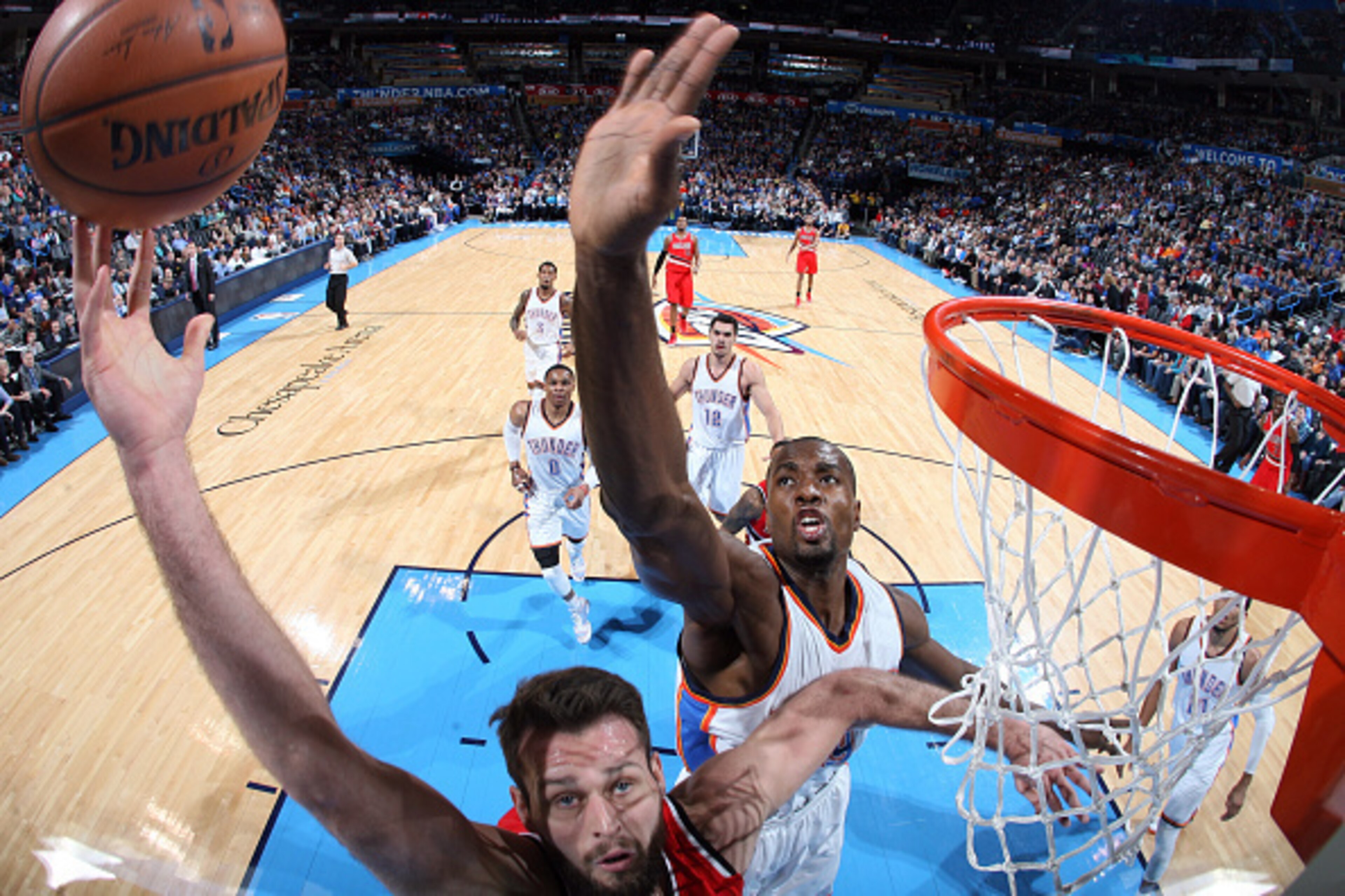 OKLAHOMA CITY, OK- DECEMBER 23: Joel Freeland #19 of the Portland Trail Blazers shoots against Serge Ibaka #9 of the Oklahoma City Thunder on December 23, 2014 at Chesapeake Energy Arena in Oklahoma City, OK. NOTE TO USER: User expressly acknowledges and 