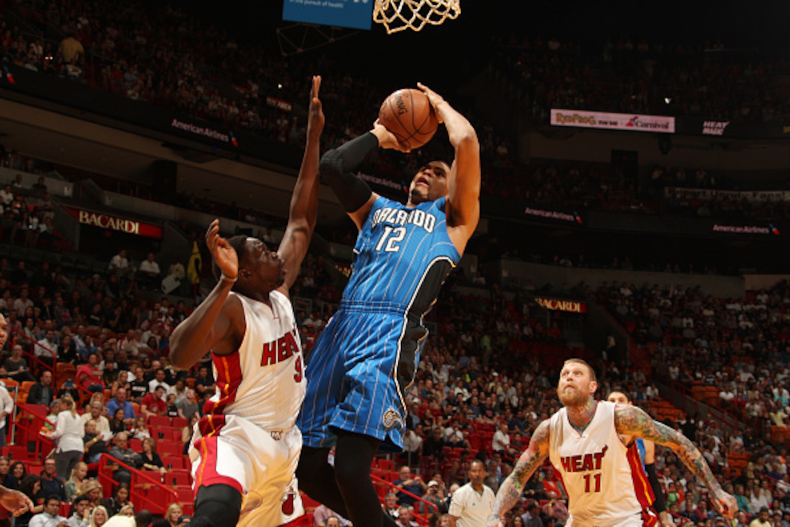 MIAMI, FL - DECEMBER 29:  Tobias Harris #12 of the Orlando Magic goes to the basket against Luol Deng #9 of the Miami Heat on December 29, 2014 at American Airlines Arena in Miami, Florida.  NOTE TO USER: User expressly acknowledges and agrees that, by do