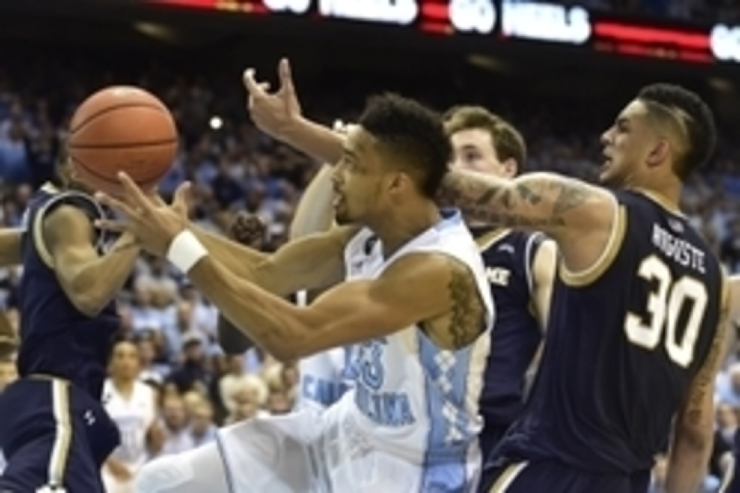 Jan 5, 2015; Chapel Hill, NC, USA; North Carolina Tar Heels forward J.P. Tokoto (13) and Notre Dame Fighting Irish forward Zach Auguste (30) fight for the ball in the second half. The Fighting Irish defeated the Tar Heels 71-70 at Dean E. Smith Center. Ma