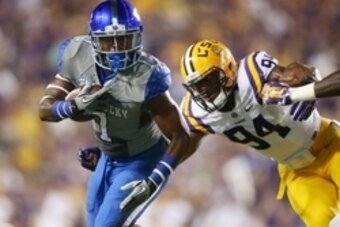 Oct 18, 2014; Baton Rouge, LA, USA; Kentucky Wildcats wide receiver Ryan Timmons (1) carries the ball in front of LSU Tigers defensive end Danielle Hunter (94) in the first half at Tiger Stadium. Mandatory Credit: Crystal LoGiudice-USA TODAY Sports