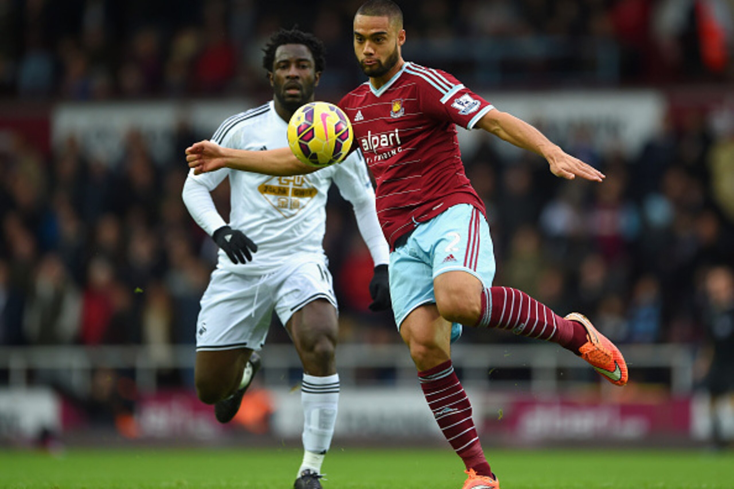 LONDON, ENGLAND - DECEMBER 07: Winston Reid of West Ham clears the ball under pressure from Wilfried Bony of Swansea City during the Barclays Premier League match between West Ham United and Swansea City at Boleyn Ground on December 7, 2014 in London, Eng