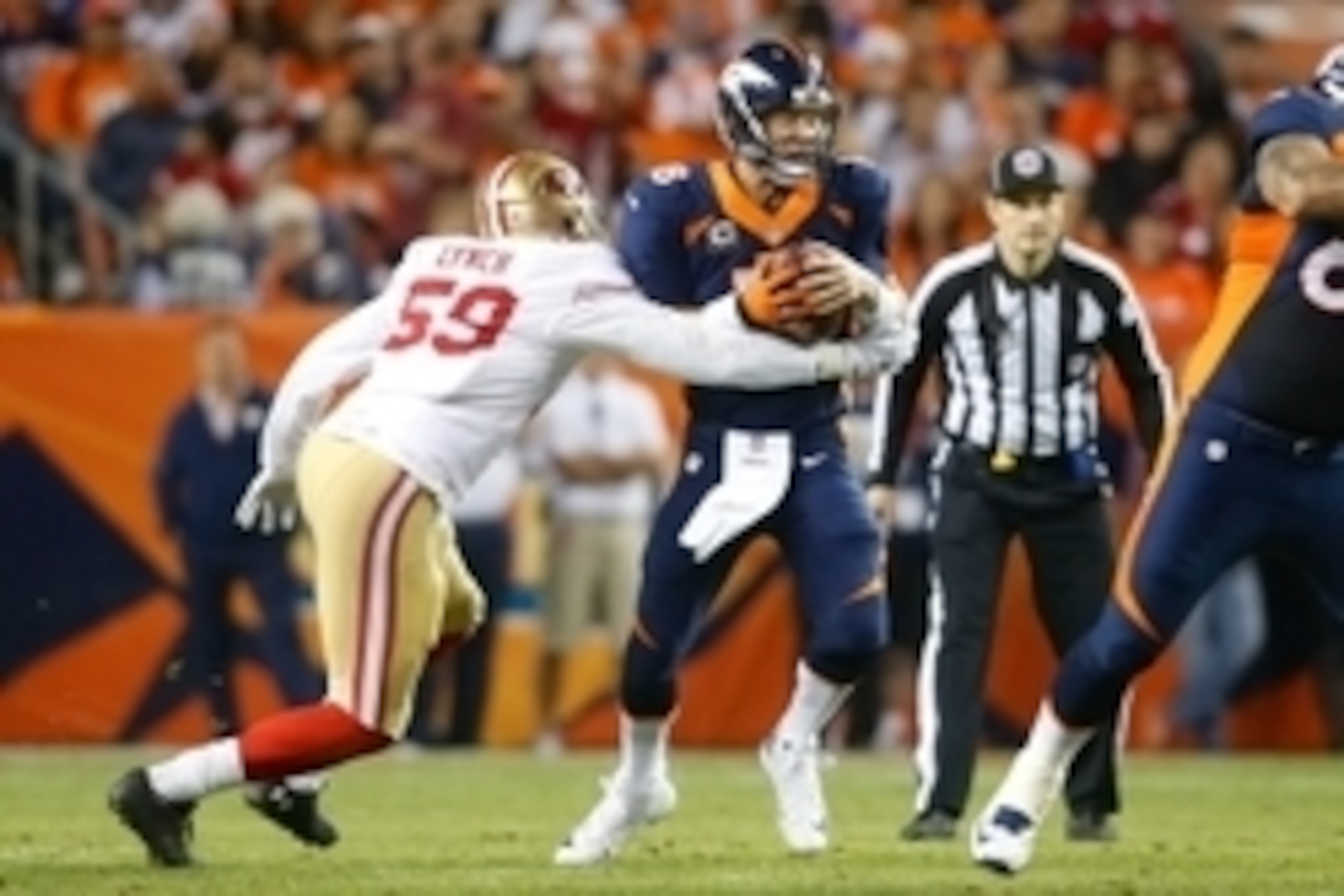 Oct 19, 2014; Denver, CO, USA; Denver Broncos quarterback Peyton Manning (18) is sacked by San Francisco 49ers linebacker Aaron Lynch (59) in the first quarter at Sports Authority Field at Mile High. Mandatory Credit: Chris Humphreys-USA TODAY Sports