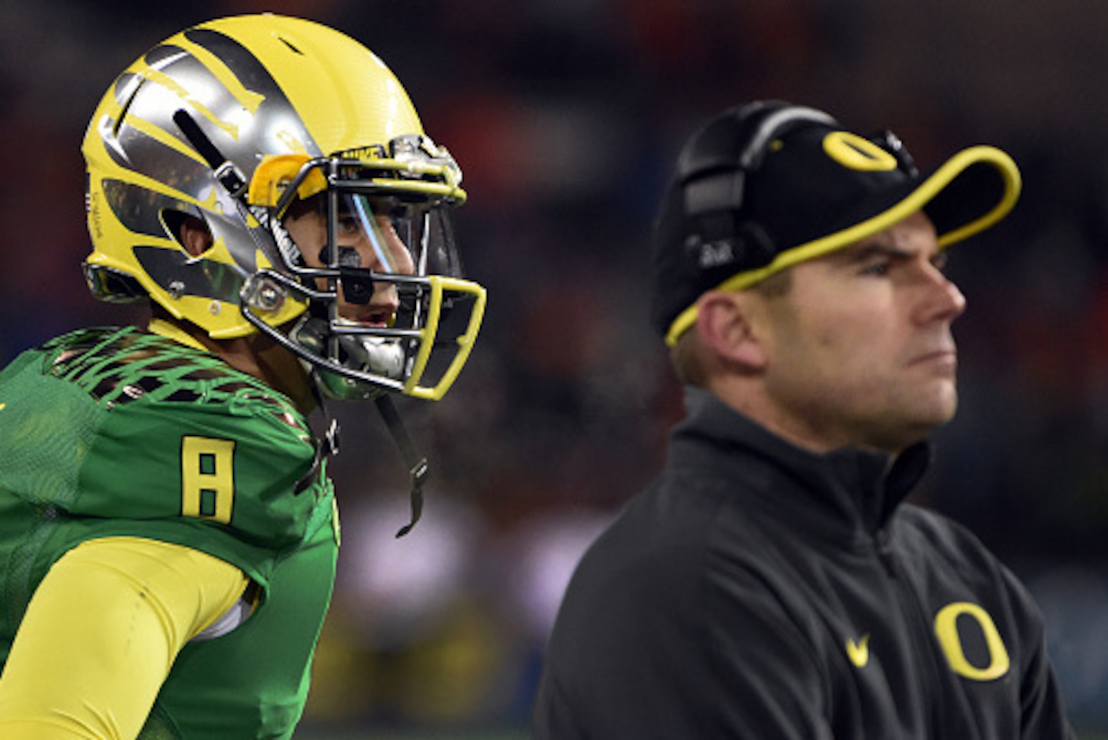 CORVALLIS, OR - NOVEMBER 29: Quarterback Marcus Mariota #8 of the Oregon Ducks and head coach Mark Helfrich of the Oregon Ducks look on from the bench during the third quarter of the game against the Oregon State Beavers at Reser Stadium on November 29, 2 CORVALLIS, OR - NOVEMBER 29: Quarterback Marcus Mariota #8 of the Oregon Ducks and head coach Mark Helfrich of the Oregon Ducks look on from the bench during the third quarter of the game against the Oregon State Beavers at Reser Stadium on November 29, 2