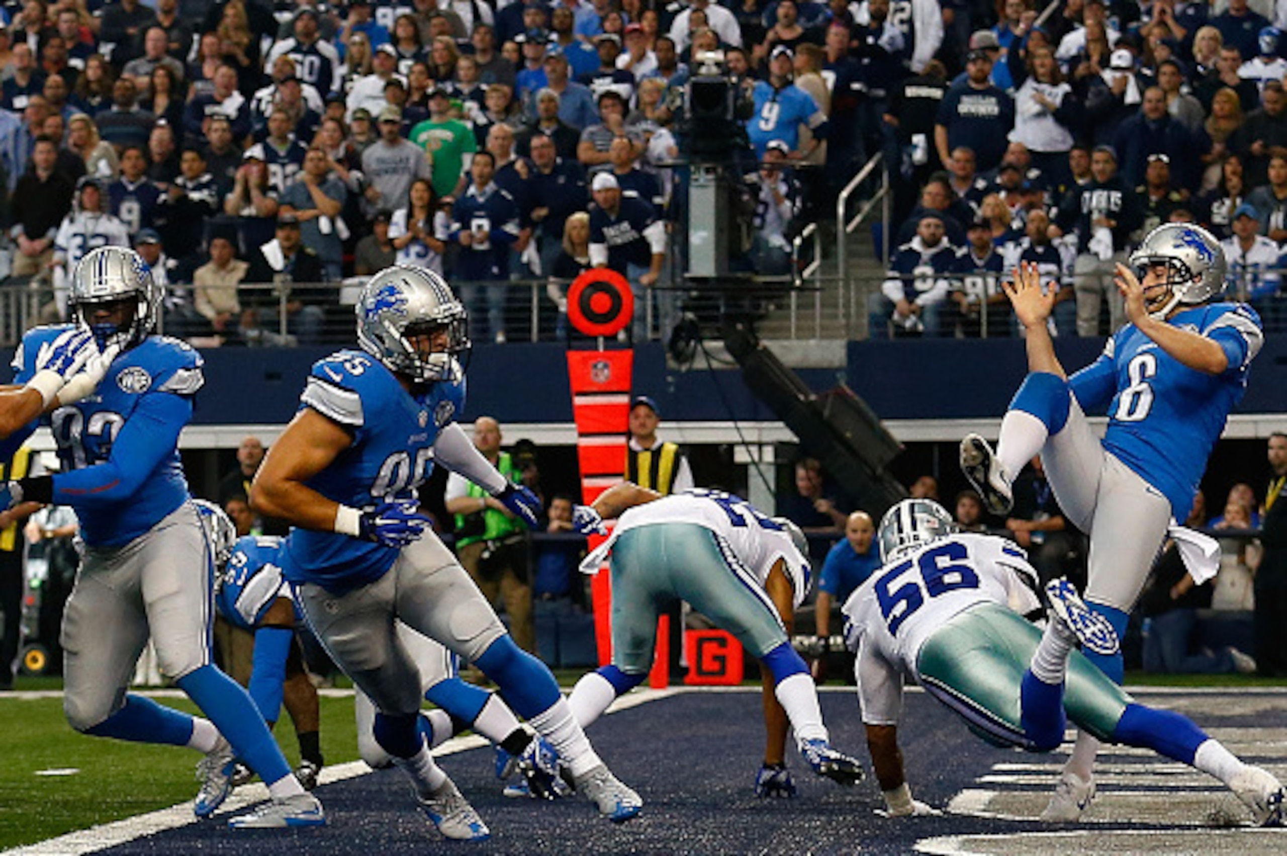 ARLINGTON, TX - JANUARY 04:  Dekoda Watson #56 of the Dallas Cowboys roughs punter Sam Martin #6 of the Detroit Lions as George Johnson #93 of the Detroit Lions and K.Van Noy #95 of the Detroit Lions block during the first half of their NFC Wild Card Play