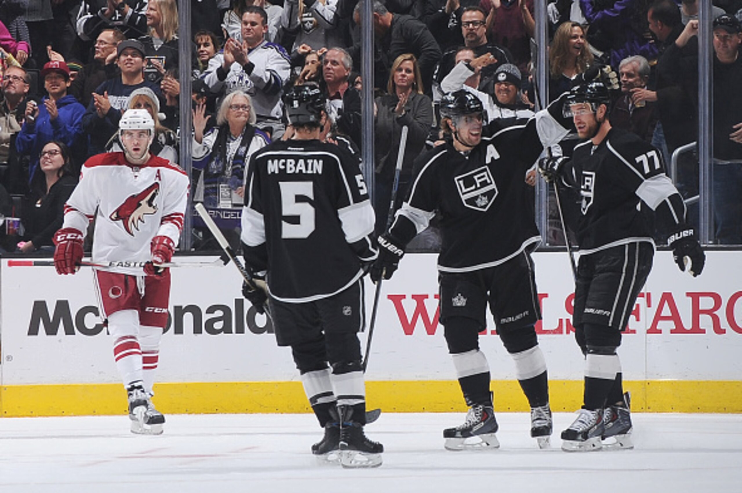 LOS ANGELES, CA - DECEMBER 20: Jamie McBain #5, Anze Kopitar #11, and Jeff Carter #77 of the Los Angeles Kings celebrate as Keith Yandle #3 of the Arizona Coyotes looks on at STAPLES Center on December 20, 2014 in Los Angeles, California. (Photo by Juan O