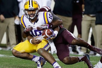 COLLEGE STATION, TX - NOVEMBER 27:  Anthony Jennings #10 of the LSU Tigers gets sacked by Devonta Burns #26 of the Texas A&M Aggies during the second half of their game at Kyle Field on November 27, 2014 in College Station, Texas.  (Photo by Scott Hallera
