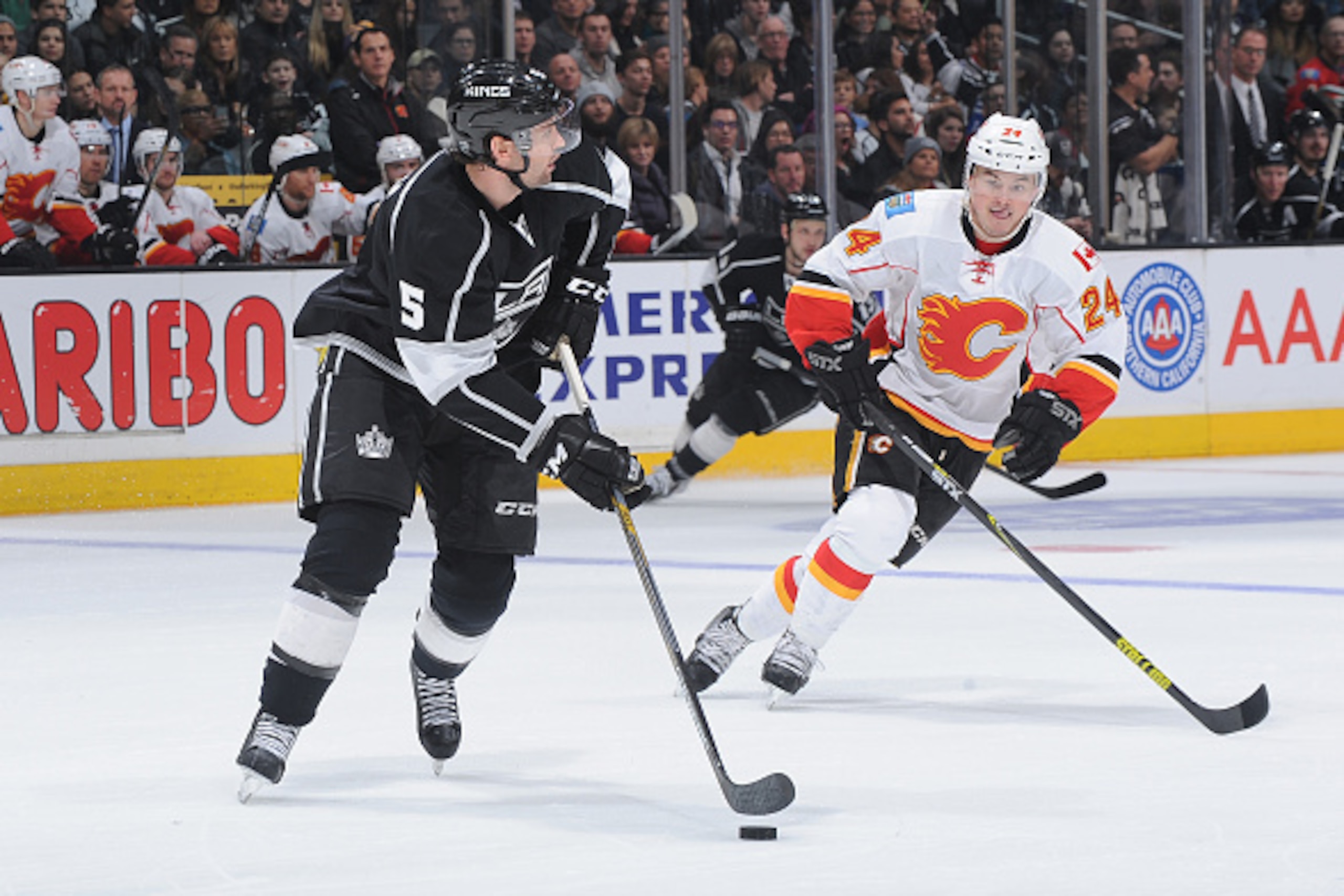 LOS ANGELES, CA - DECEMBER 22: Jamie McBain #5 of the Los Angeles Kings handles the puck against Jiri Hudler #24 of the Calgary Flames at STAPLES Center on December 22, 2014 in Los Angeles, California. (Photo by Juan Ocampo/NHLI via Getty Images)