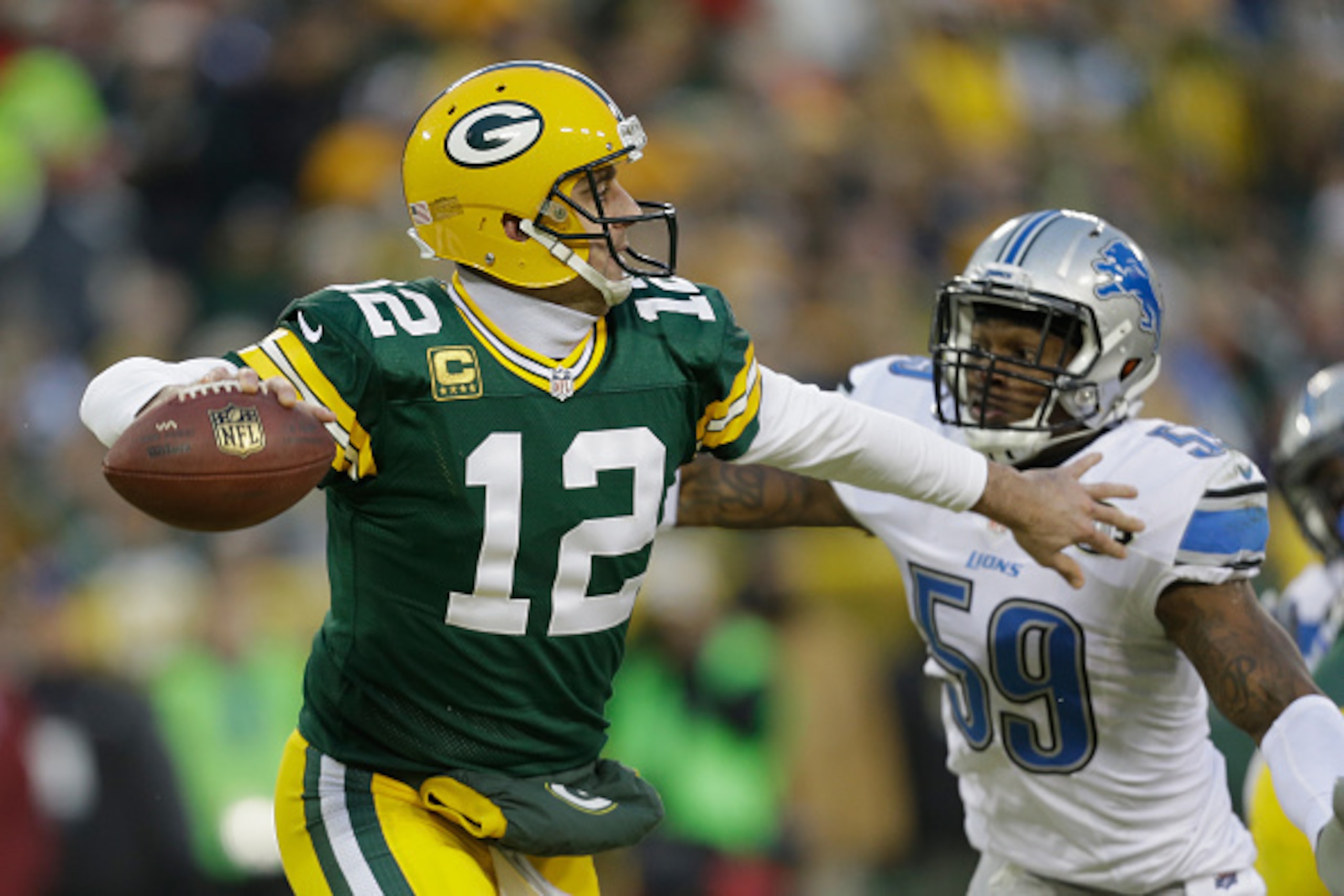 GREEN BAY, WI - DECEMBER 28:  Quarterback Aaron Rodgers #12 of the Green Bay Packers looks to pass against middle linebacker Tahir Whitehead #59 of the Detroit Lions in the second half of the NFL game at Lambeau Field on December 28, 2014 in Green Bay, Wi
