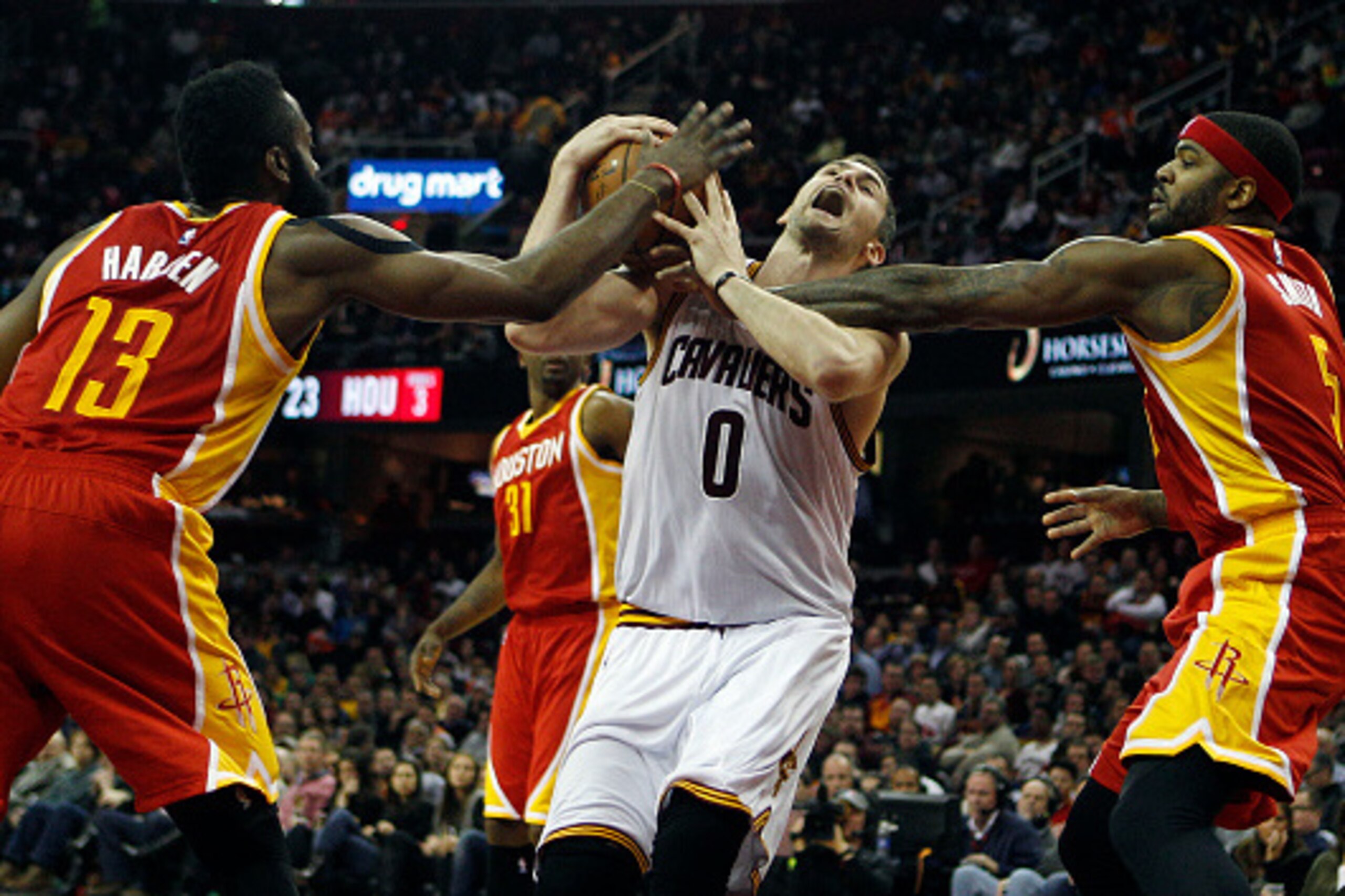 CLEVELAND, OH - JANUARY 7:  Kevin Love #0 of the Cleveland Cavaliers is defended by James Harden #13 and Josh Smith #5 of the Houston Rockets during the first half of their game on January 7, 2015 at Quicken Loans Arena  in Cleveland, Ohio. NOTE TO USER: 