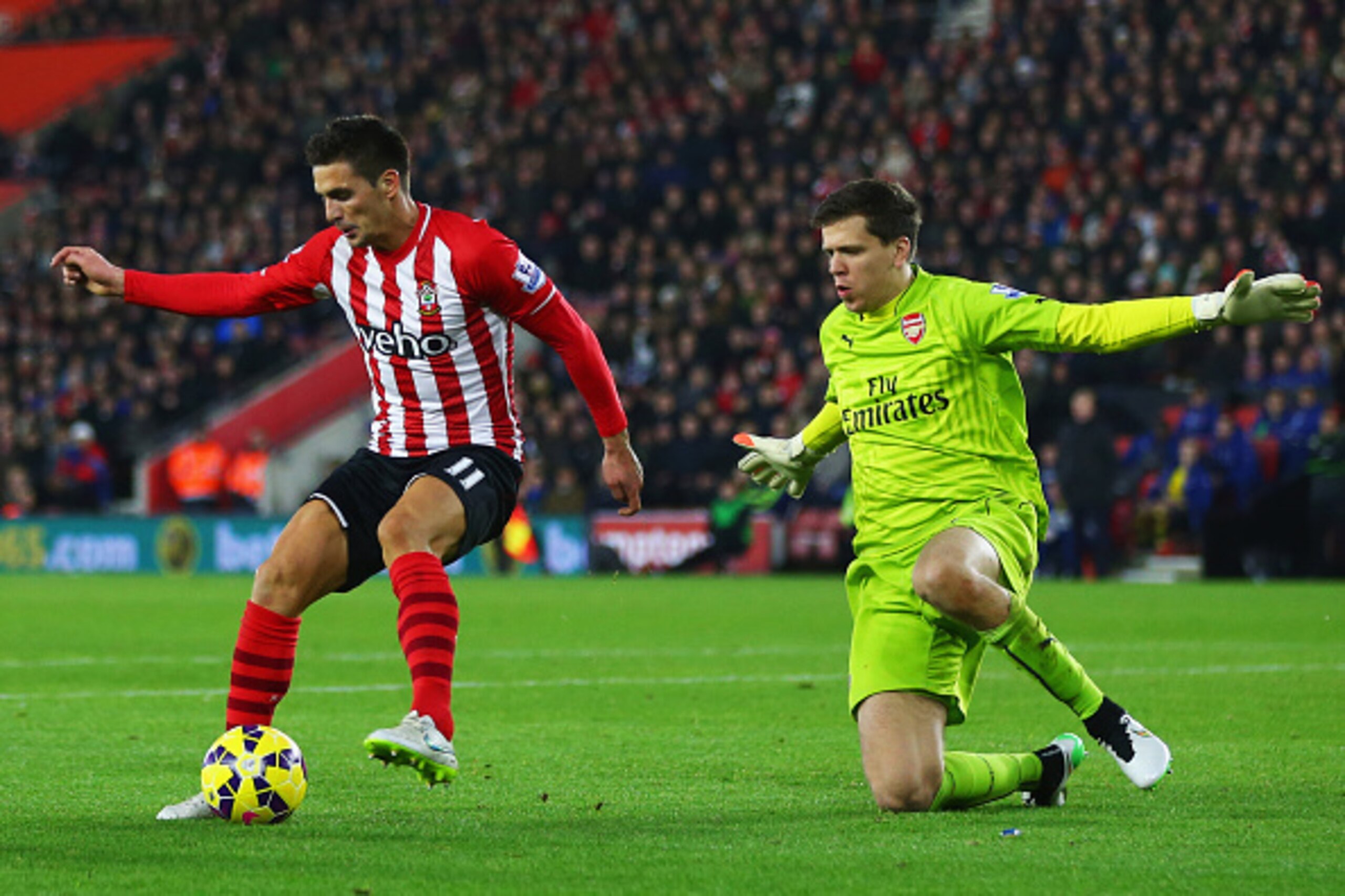 SOUTHAMPTON, ENGLAND - JANUARY 01:  Dusan Tadic of Southampton is watched by Wojciech Szczesny of Arsenal during the Barclays Premier League match between Southampton and Arsenal at St Mary's Stadium on January 1, 2015 in Southampton, England.  (Photo by 