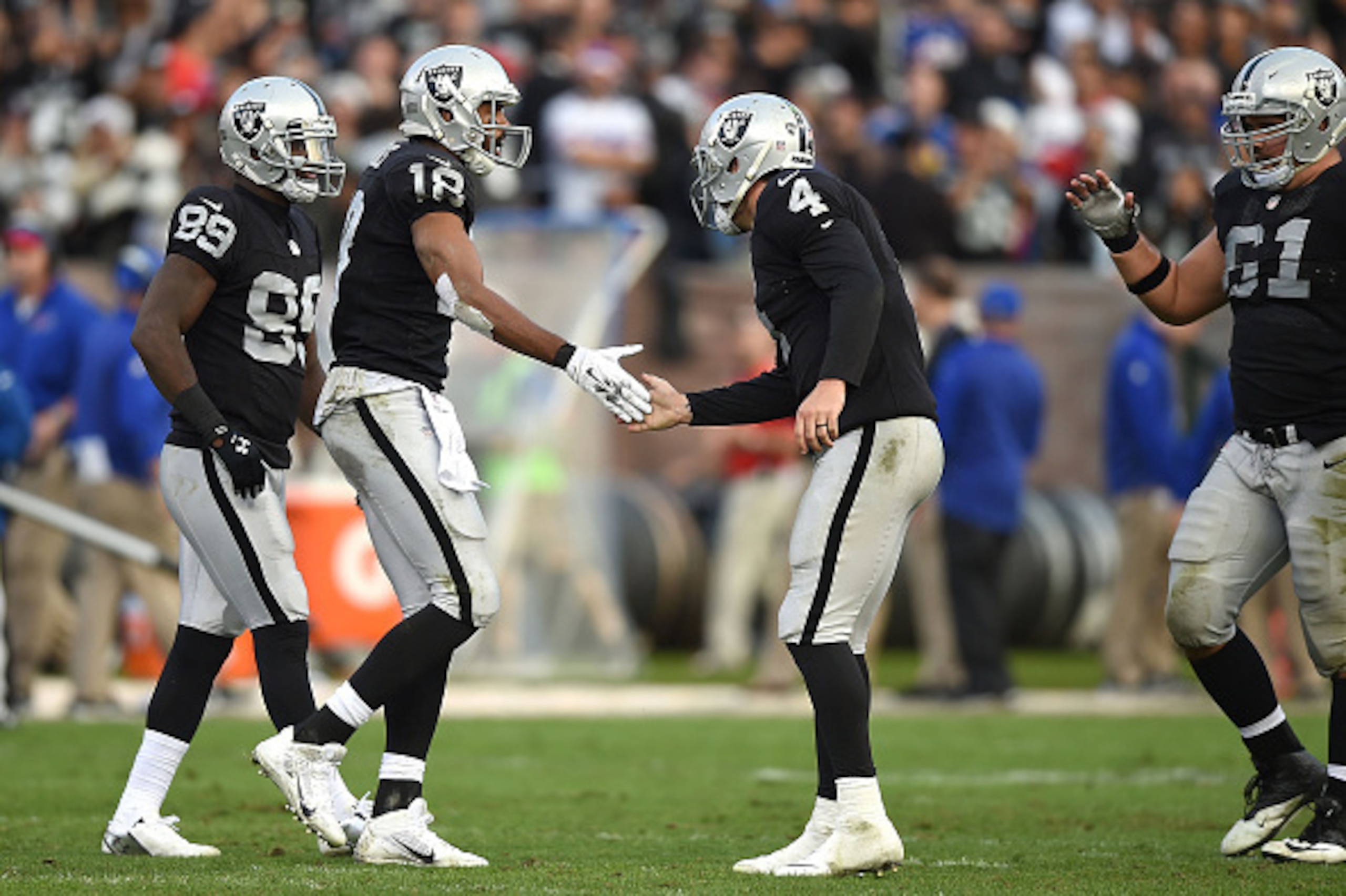 OAKLAND, CA - DECEMBER 21:  Derek Carr #4 of the Oakland Raiders congratulates Andre Holmes #18 of the Oakland Raiders on a 51-yard completion in the fourth quarter against the Buffalo Bills at O.co Coliseum on December 21, 2014 in Oakland, California.  (