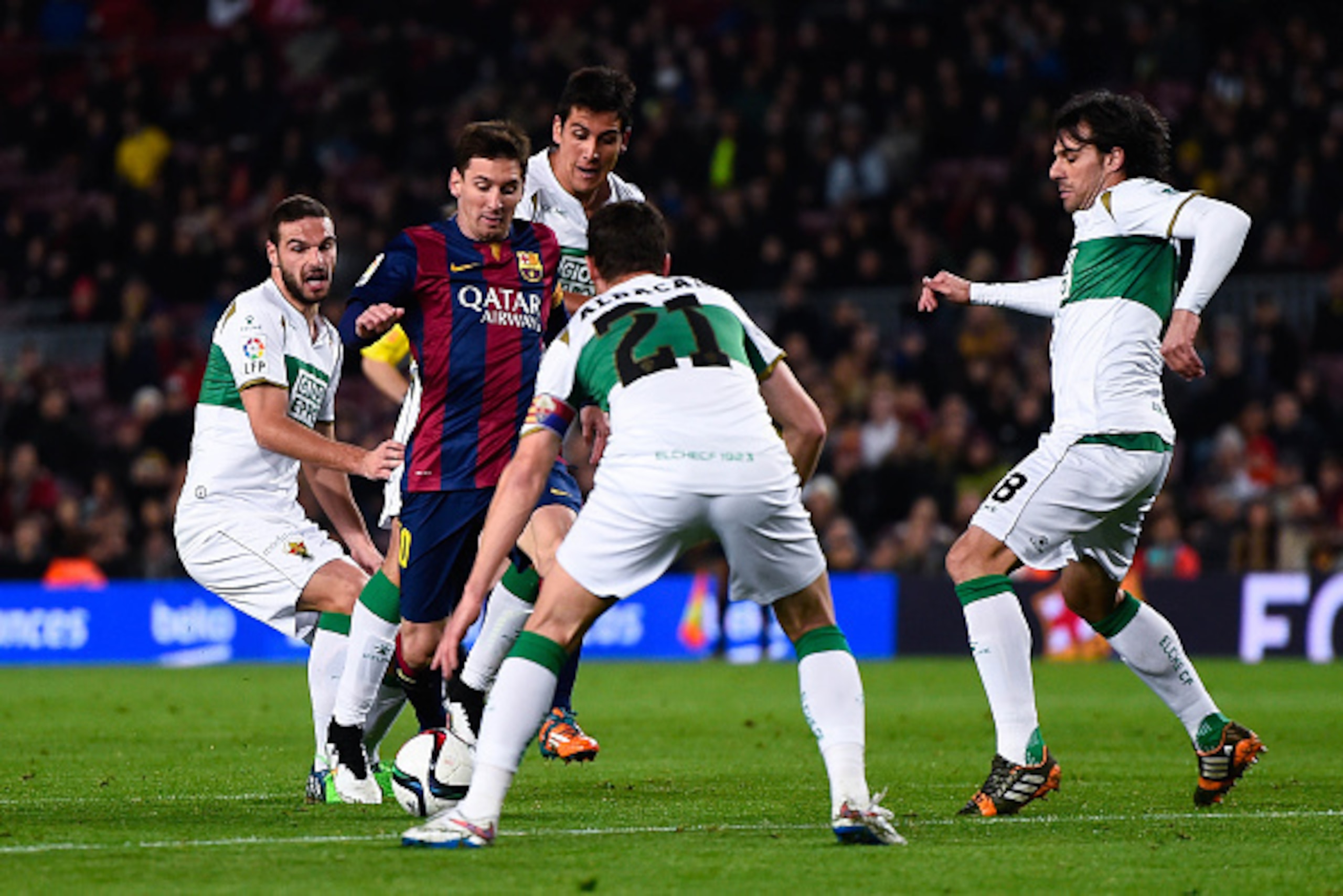 BARCELONA, SPAIN - JANUARY 08:  Lionel Messi of FC Barcelona competes for the ball among Elche FC players during the Copa del Rey  Round of 16 First Leg match between FC Barcelona and Elche CF at Camp Nou on January 8, 2015 in Barcelona, Spain.  (Photo by