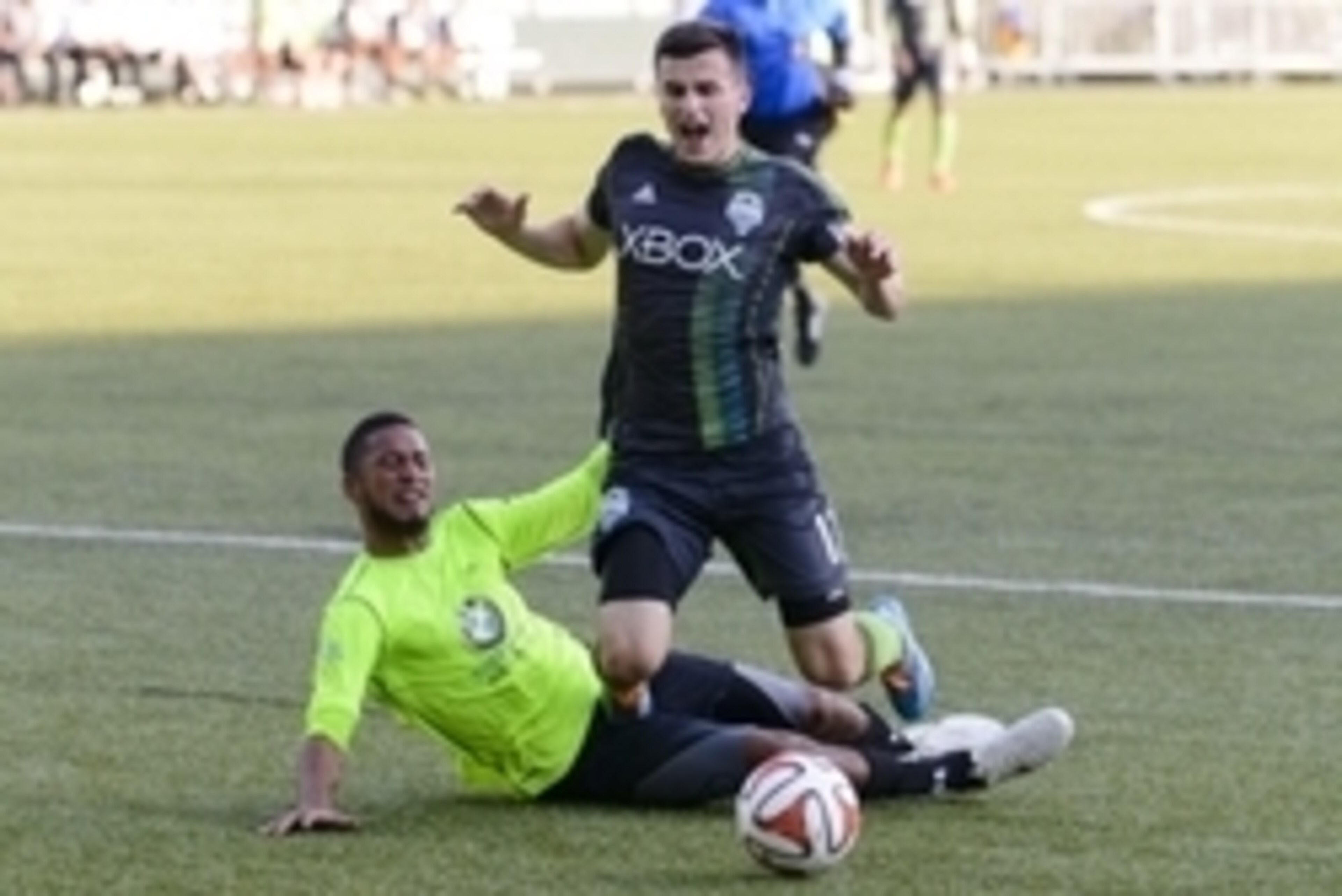 Jun 18, 2014; Tukwila, WA, USA; PSA Elite defender Aaron Simmons (5) tackles Seattle Sounders FC midfielder Aaron Kovar (11) in the goal box resulting in a penalty kick during the first half at Starfire Sports Complex. Mandatory Credit: Steven Bisig-USA T