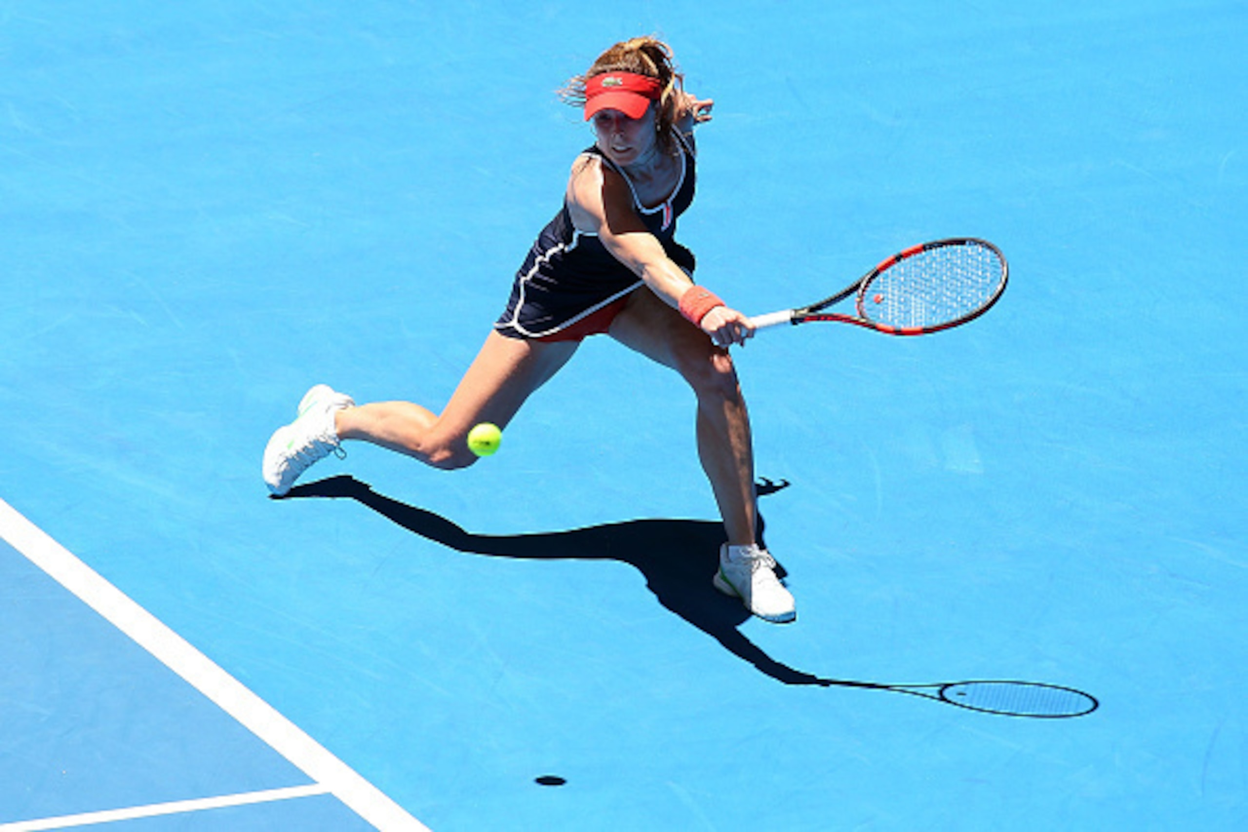 PERTH, AUSTRALIA - JANUARY 09:  Alize Cornet of France plays a backhand in her singles match against Agnieszka Radwanska of Poland during day six of the 2015 Hopman Cup at Perth Arena on January 9, 2015 in Perth, Australia.  (Photo by Paul Kane/Getty Imag