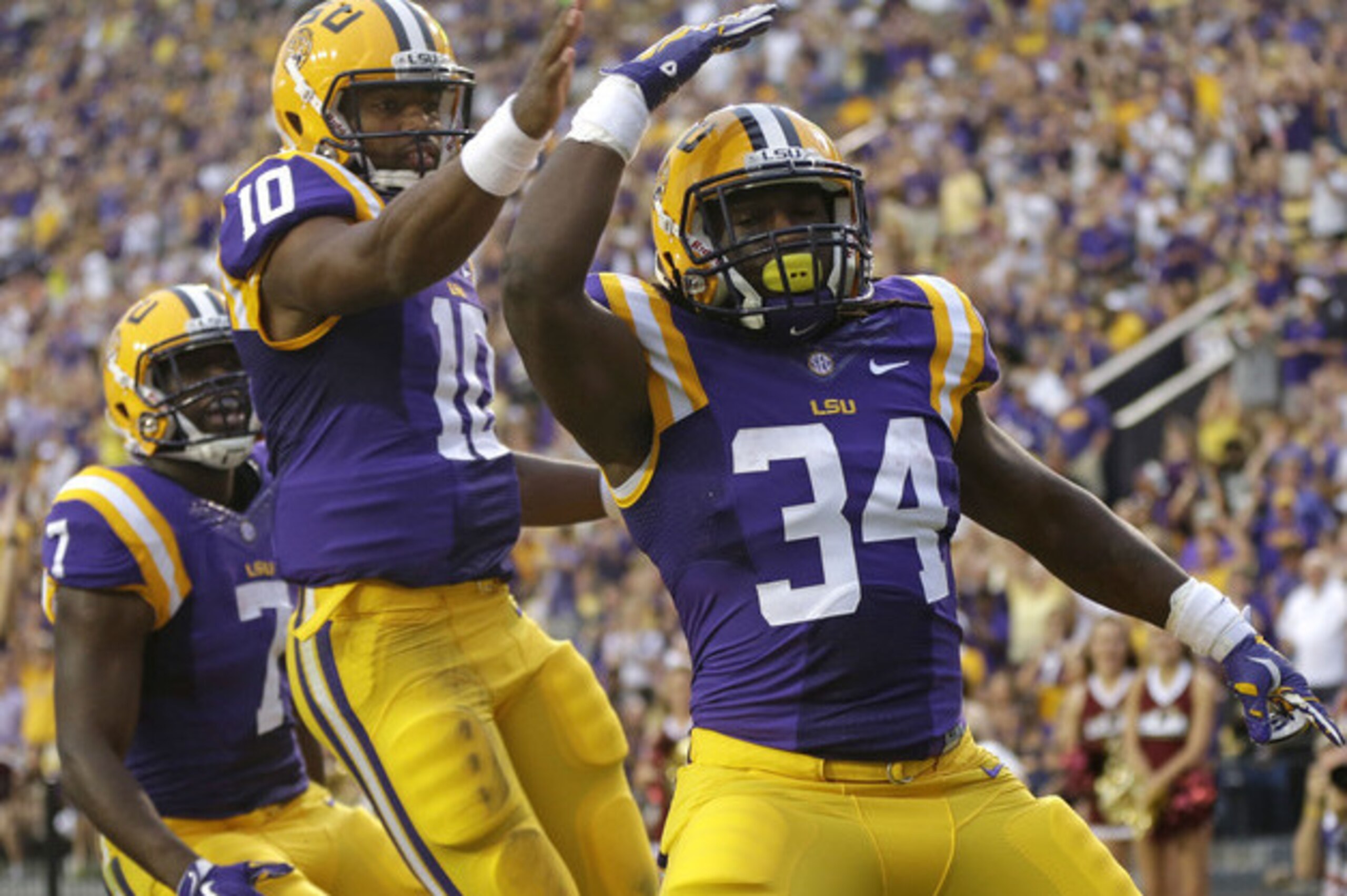 LSU's Leonard Fournette (No. 7) and Anthony Jennings (No. 10) celebrate a Darrel Williams (No. 34) touchdown run.