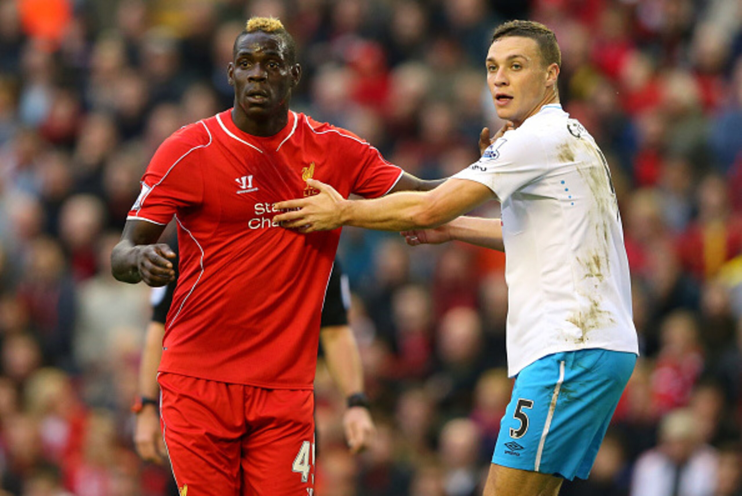 LIVERPOOL, ENGLAND - OCTOBER 25:  Mario Balotelli of Liverpool and James Chester of Hull City tussle for positions during a corner kick in the Barclays Premier League match between Liverpool and Hull City at Anfield on October 25, 2014 in Liverpool, Engla