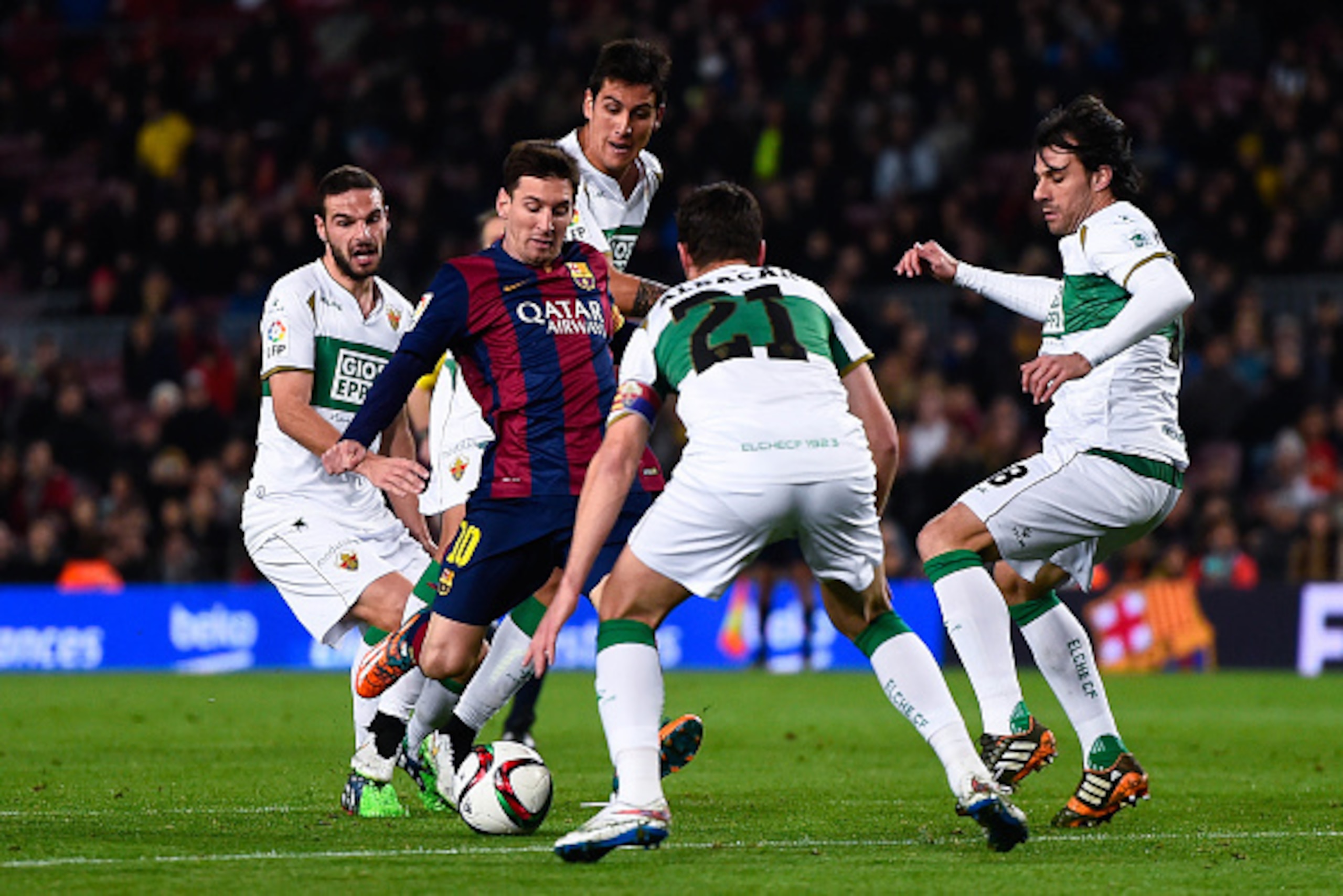 BARCELONA, SPAIN - JANUARY 08:  Lionel Messi of FC Barcelona competes for the ball among Elche FC players during the Copa del Rey  Round of 16 First Leg match between FC Barcelona and Elche CF at Camp Nou on January 8, 2015 in Barcelona, Spain.  (Photo by