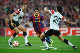 LONDON, ENGLAND - MAY 28:  Lionel Messi of FC Barcelona (C) runs with the ball as Rio Fedinand of Manchester United watches on during the UEFA Champions League final between FC Barcelona and Manchester United FC at Wembley Stadium on May 28, 2011 in Londo