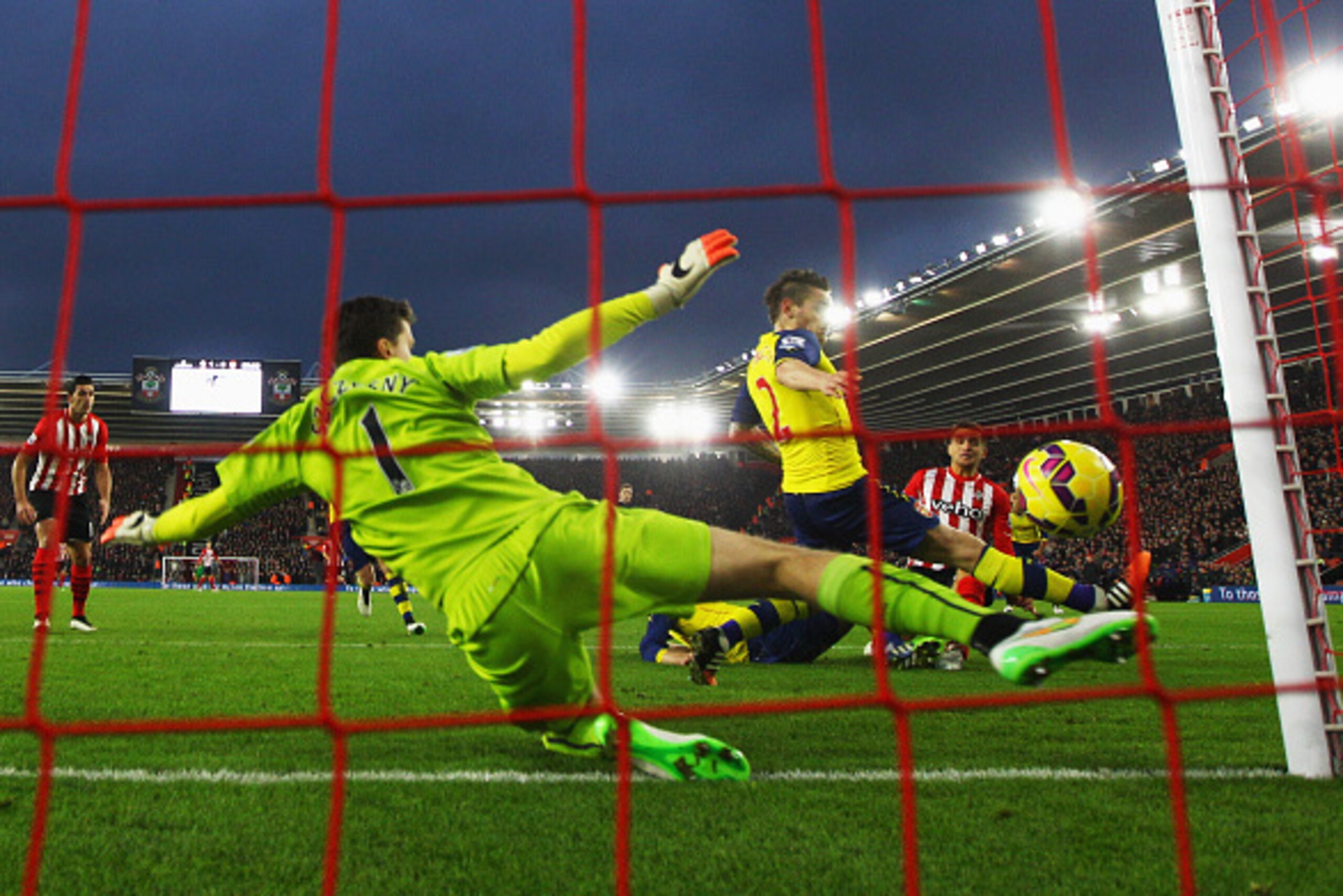 SOUTHAMPTON, ENGLAND - JANUARY 01:  Dusan Tadic of Southampton (R) scores their second goal past Wojciech Szczesny (1) and Mathieu Debuchy of Arsenal (2) during the Barclays Premier League match between Southampton and Arsenal at St Mary's Stadium on Janu