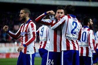 MADRID, SPAIN - JANUARY 07:  Jose Maria Gimenez (L) of Atletico de Madrid shows his shinpad with the name Lauti printed on it as he celebrates scoring his second goal with his teammates Diego Godin (R) and Mario Suarez (L) during the Copa del Rey Round of
