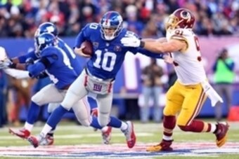 Dec 14, 2014; East Rutherford, NJ, USA; New York Giants quarterback Eli Manning (10) is sacked by Washington Redskins outside linebacker Ryan Kerrigan (91) during the third quarter of a game at MetLife Stadium. Mandatory Credit: Brad Penner-USA TODAY Spor