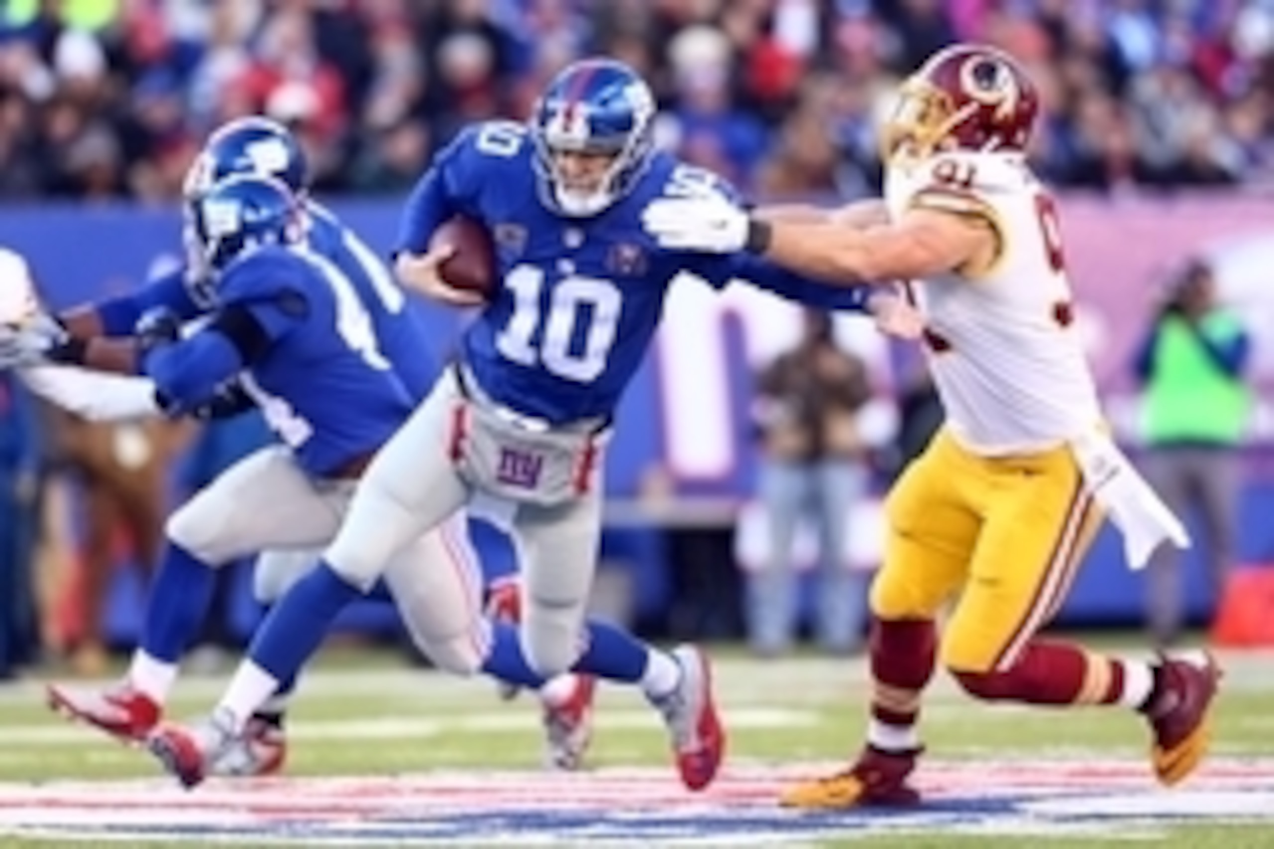 Dec 14, 2014; East Rutherford, NJ, USA; New York Giants quarterback Eli Manning (10) is sacked by Washington Redskins outside linebacker Ryan Kerrigan (91) during the third quarter of a game at MetLife Stadium. Mandatory Credit: Brad Penner-USA TODAY Spor