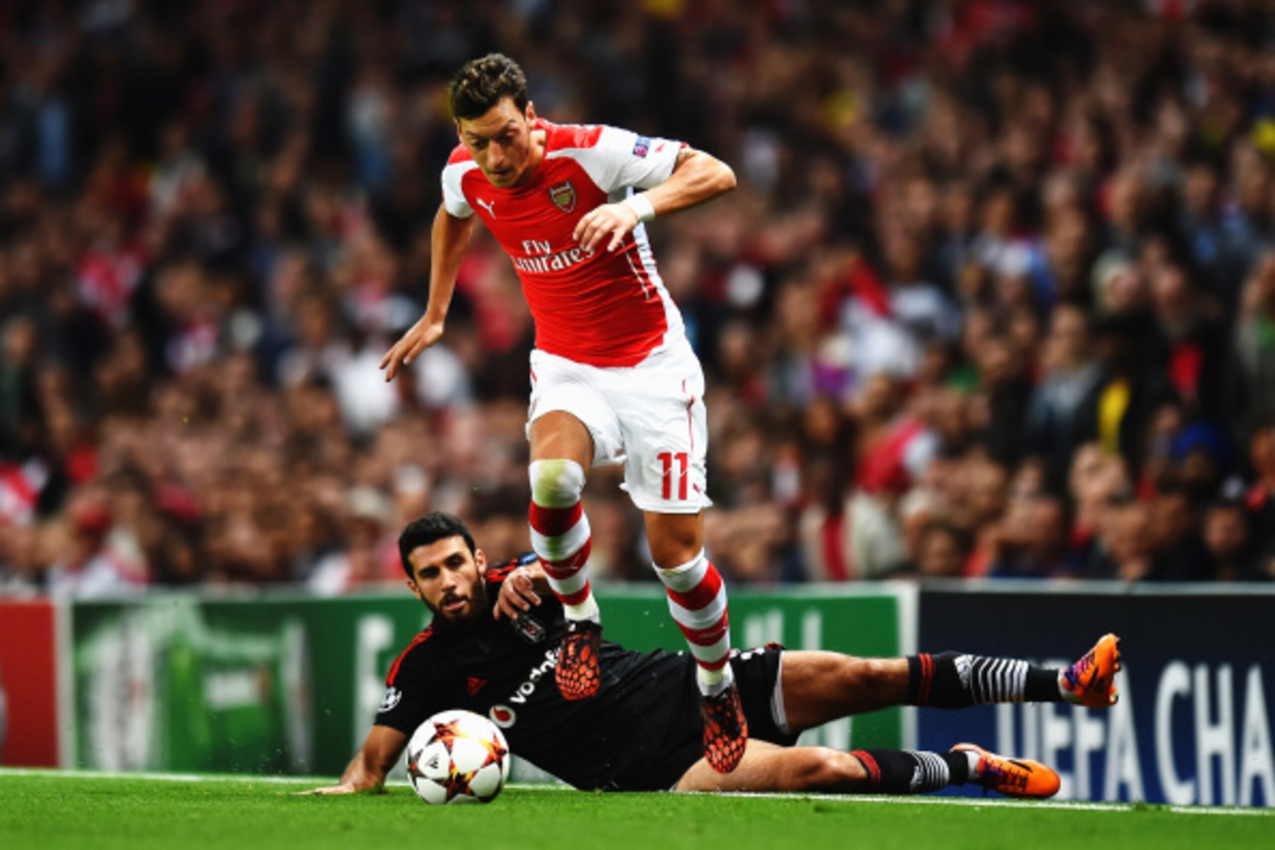 LONDON, ENGLAND - AUGUST 27:  Mesut Oezil of Arsenal skips the tackle of Ismail Koybasl of Besiktas during the UEFA Champions League Qualifier 2nd leg match between Arsenal and Besiktas at the Emirates Stadium on August 27, 2014 in London, United Kingdom.