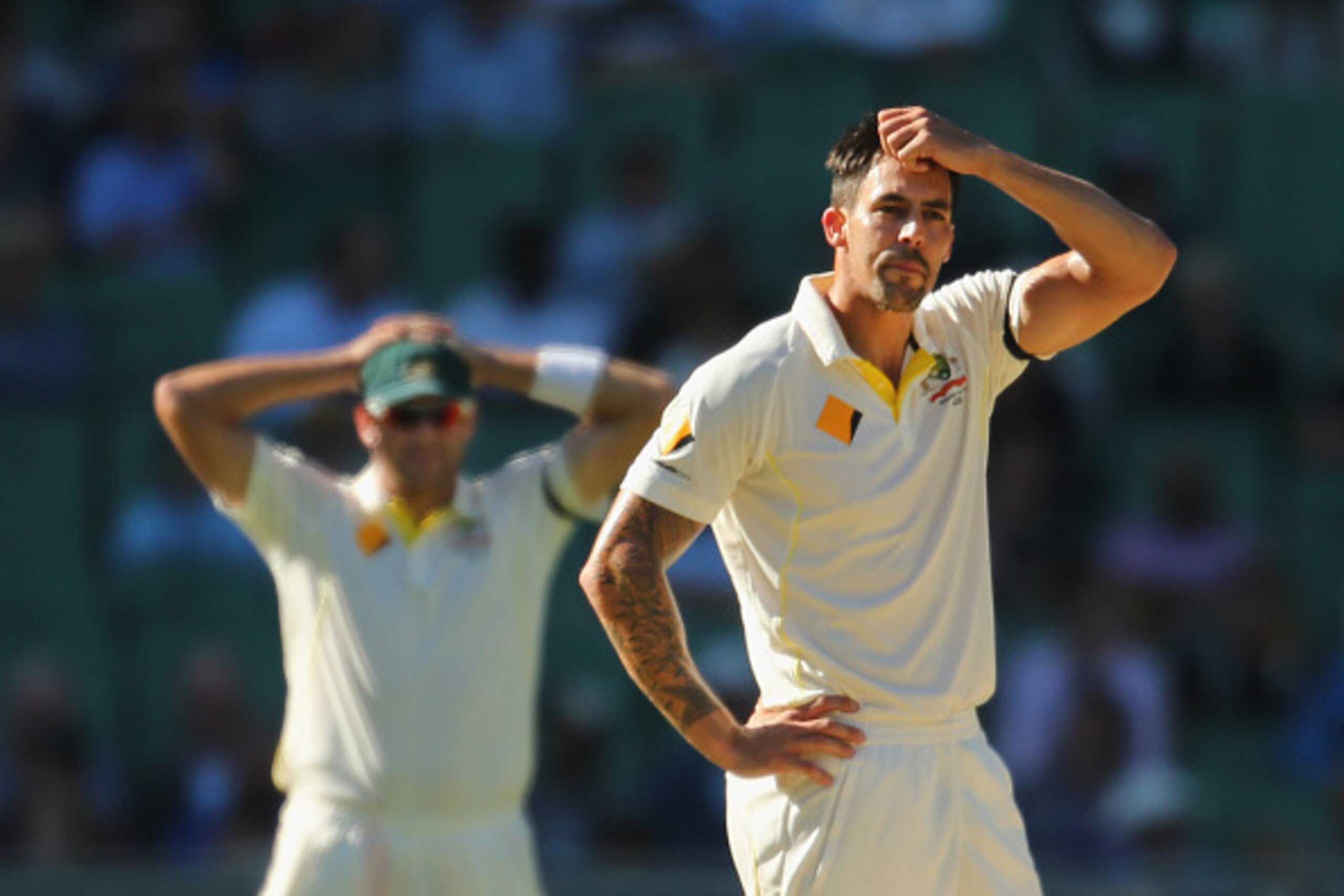 MELBOURNE, AUSTRALIA - DECEMBER 27:  Mitchell Johnson of Australia reacts after being hit for a boundary as Ryan Harris looks on during day two of the Third Test match between Australia and India at Melbourne Cricket Ground on December 27, 2014 in Melbour