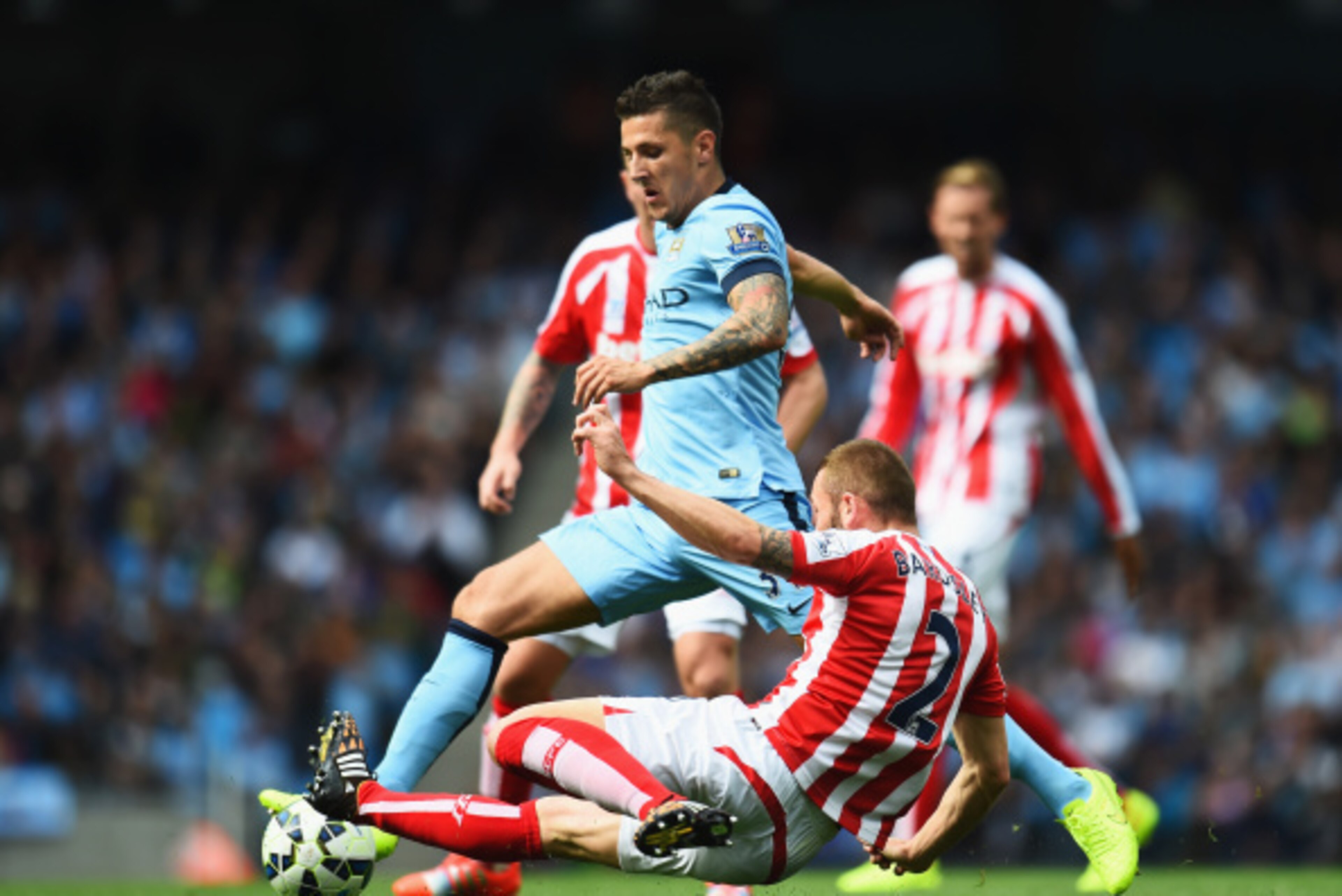 MANCHESTER, ENGLAND - AUGUST 30: Stevan Jovetic of Manchester City is tackled by Phillip Bardsley of Stoke City during the Barclays Premier League match between Manchester City and Stoke City at Etihad Stadium on August 30, 2014 in Manchester, England.  (
