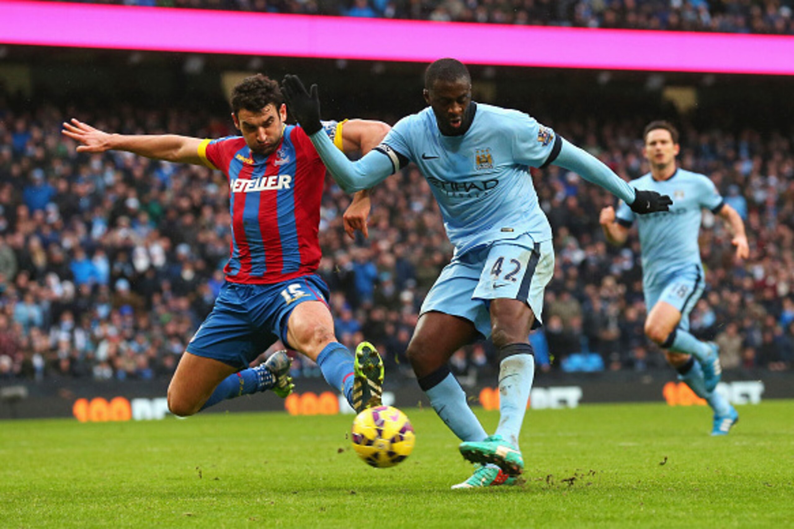 MANCHESTER, ENGLAND - DECEMBER 20: Yaya Toure of Manchester City scores his goal challenged by Mile Jedinak of Crystal Palace during the Barclays Premier League match between Manchester City and Crystal Palace at Etihad Stadium on December 20, 2014 in Ma MANCHESTER, ENGLAND - DECEMBER 20: Yaya Toure of Manchester City scores his goal challenged by Mile Jedinak of Crystal Palace during the Barclays Premier League match between Manchester City and Crystal Palace at Etihad Stadium on December 20, 2014 in Ma
