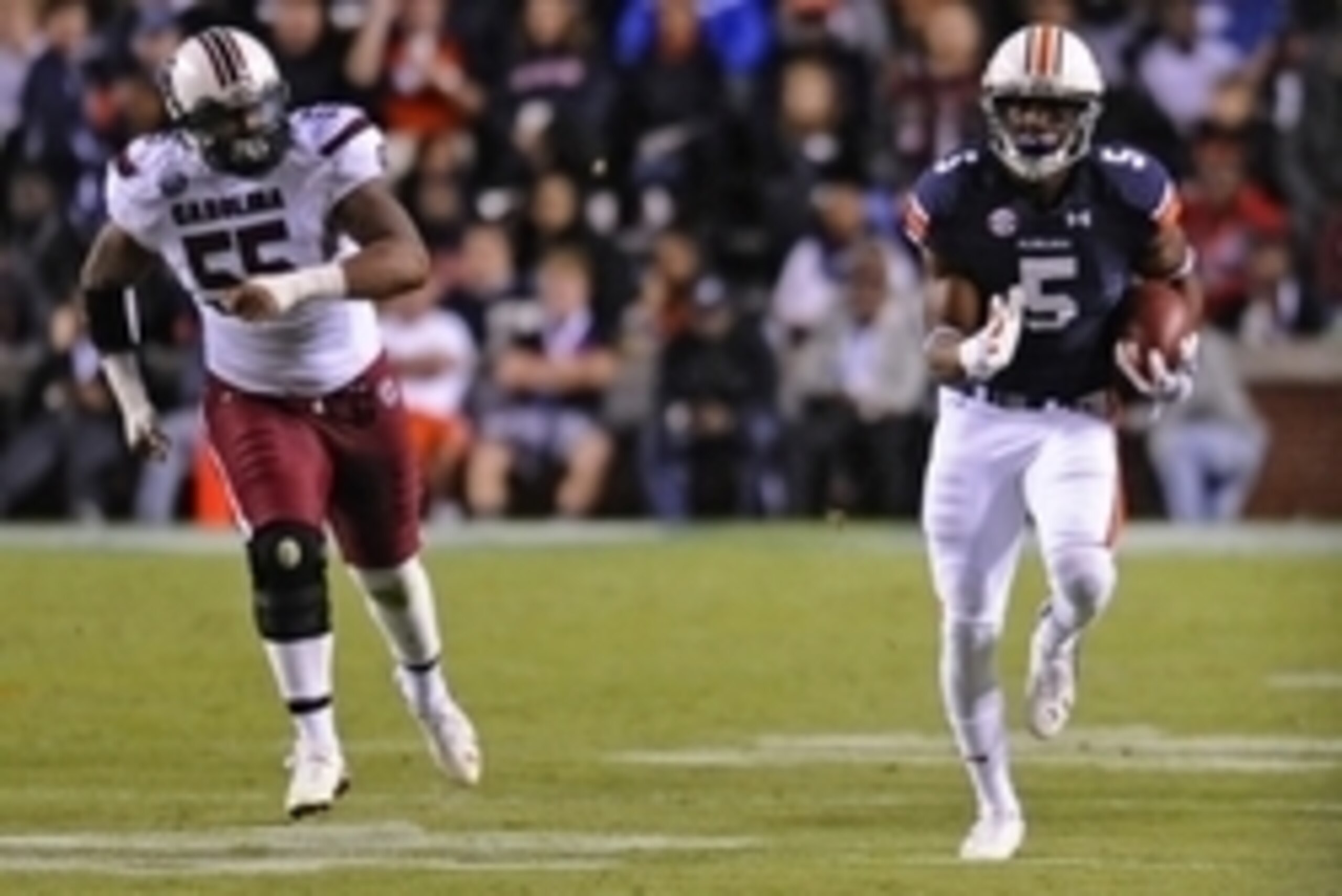 Oct 25, 2014; Auburn, AL, USA; Auburn Tigers wide receiver Ricardo Louis (5) runs the ball for a touchdown past South Carolina Gamecocks defensive end David Johnson (55) during the third quarter at Jordan Hare Stadium. Auburn won 42-35. Mandatory Credit: 