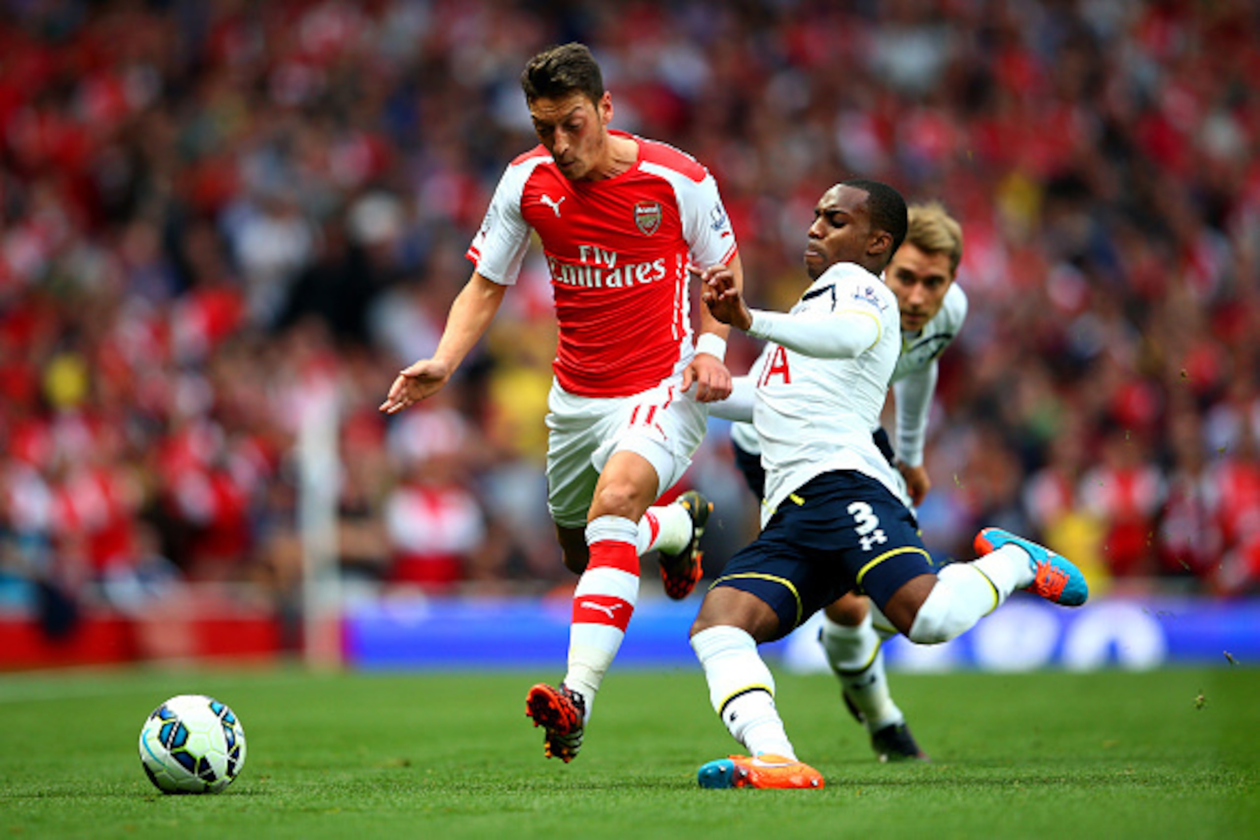 LONDON, ENGLAND - SEPTEMBER 27:  Mesut Oezil of Arsenal in action against Danny Rose of Spurs during the Barclays Premier League match between Arsenal and Tottenham Hotspur at Emirates Stadium on September 27, 2014 in London, England.  (Photo by Paul Gilh