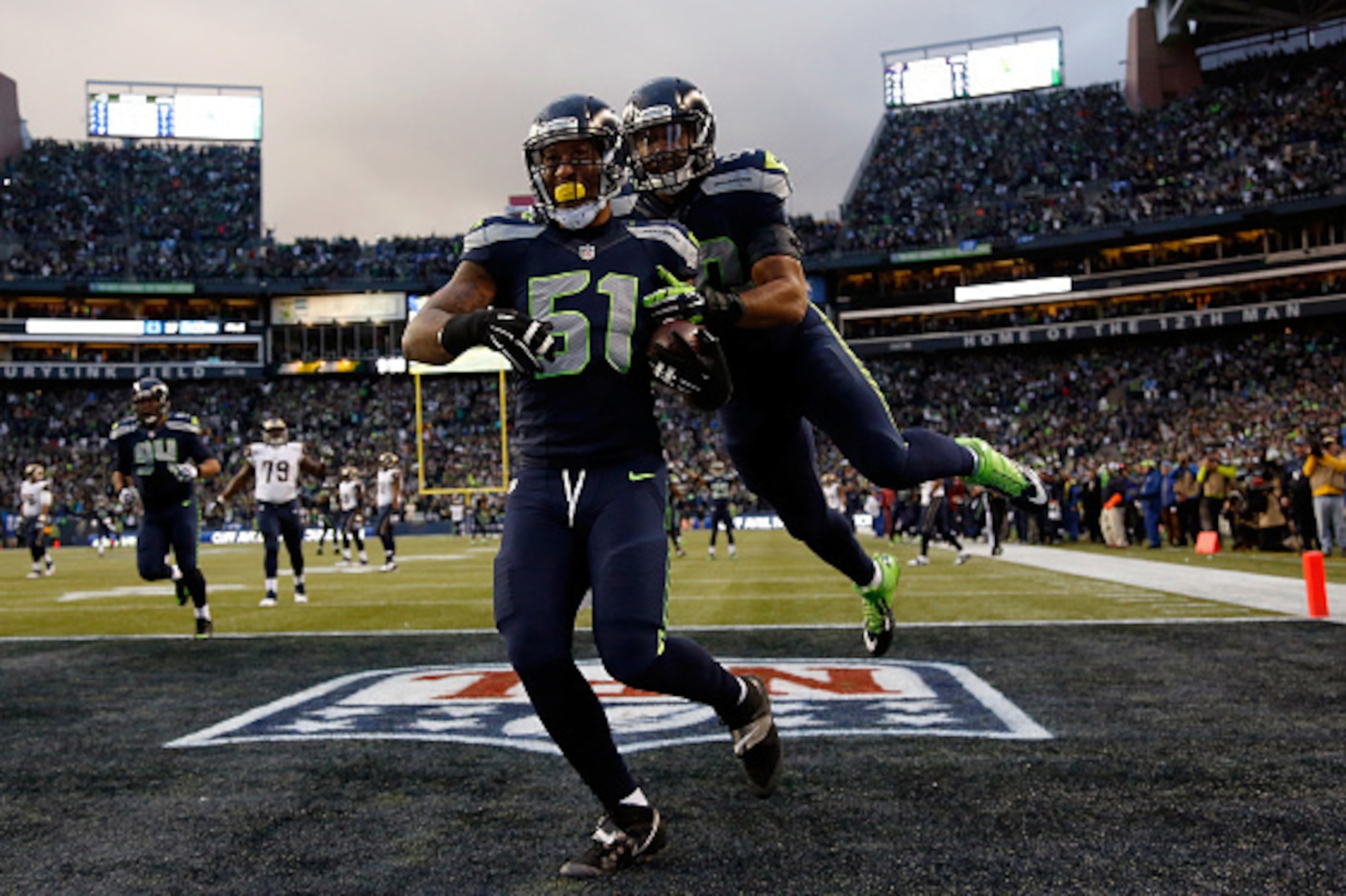 SEATTLE, WA - DECEMBER 28:  Outside linebacker Bruce Irvin #51 of the Seattle Seahawks celebrates with outside linebacker K.J. Wright #50 of the Seattle Seahawks after running an interception back 49 yards for a touchdown during the fourth quarter of the 