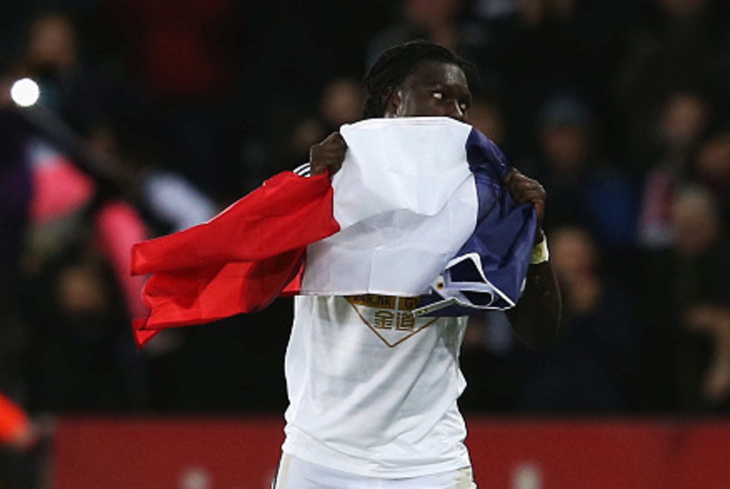 SWANSEA, WALES - JANUARY 10:  Bafetibi Gomis of Swansea celebrates his team's second goal with the French flag during the Barclays Premier League match between Swansea City and West Ham United at Liberty Stadium on January 10, 2015 in Swansea, Wales.  (Ph