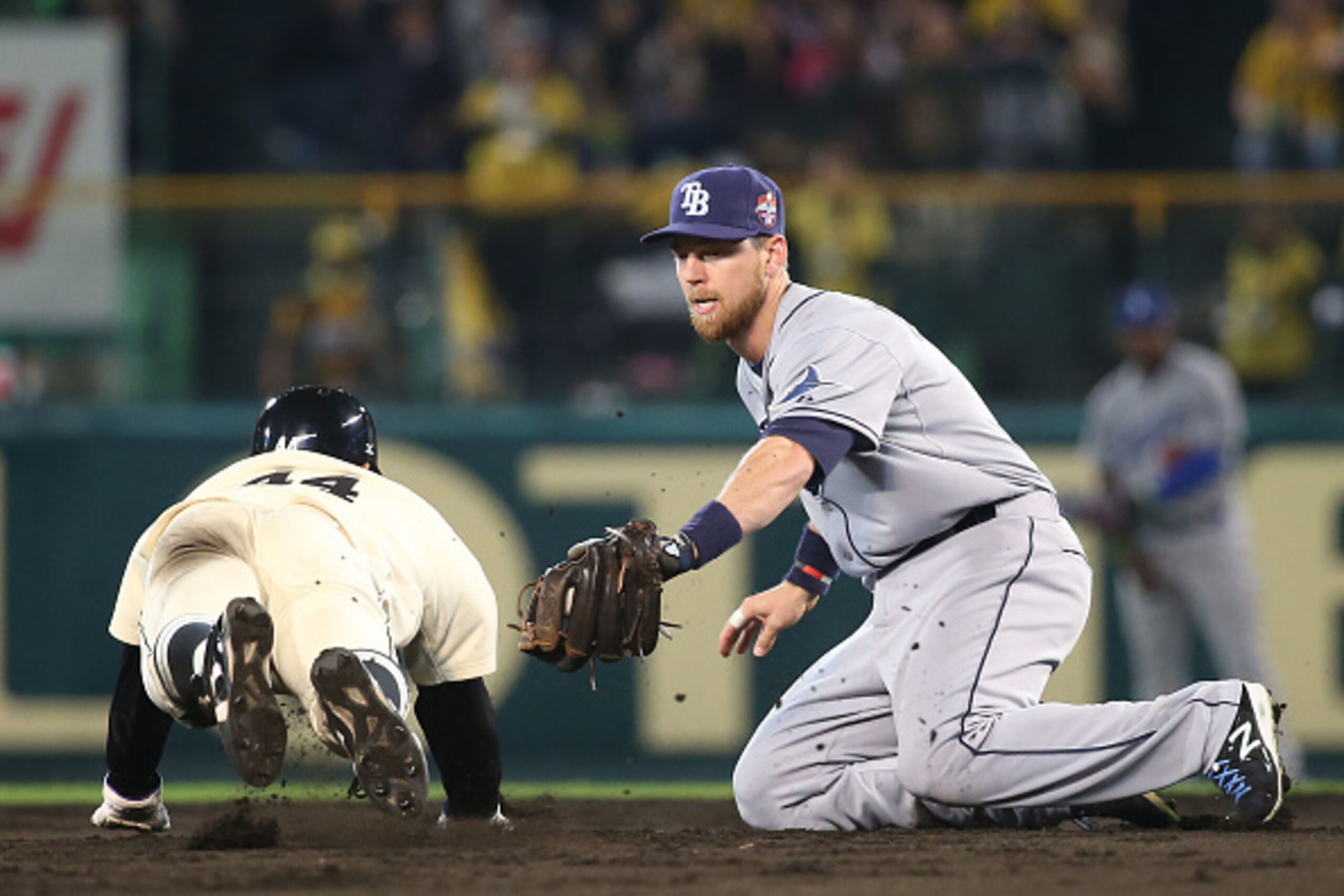 NISHINOMIYA, JAPAN - NOVEMBER 11:  Ben Zobrist #18 of the Tampa Bay Rays tags out Taishi Ohta #44 of Hanshin Tigers and Yomiuri Giants during the friendly match between Hanshin Tigers and Yomiuri Giants at the Hanshin Koshien Stadium on November 11, 2014