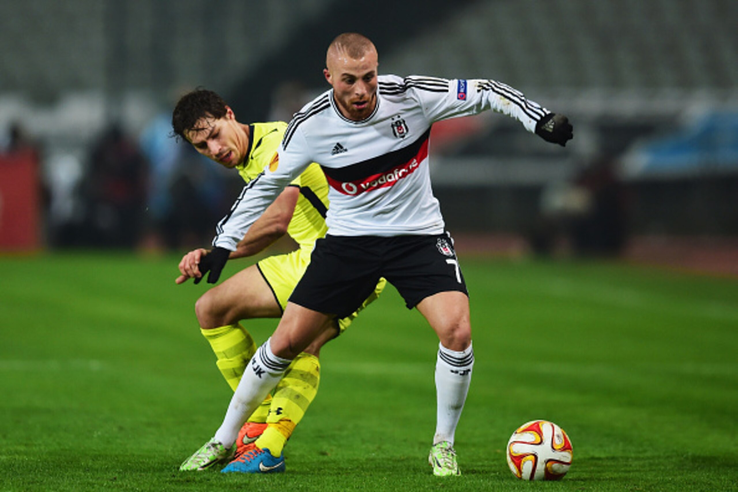 ISTANBUL, TURKEY - DECEMBER 11:  Gokhan Tore of Besiktas holds off Benjamin Stambouli of Spurs during the UEFA Europa League Group C match between Besiktas JK and Tottenham Hotspur FC at Ataturk Olympic Stadium on December 11, 2014 in Istanbul, Turkey.  (